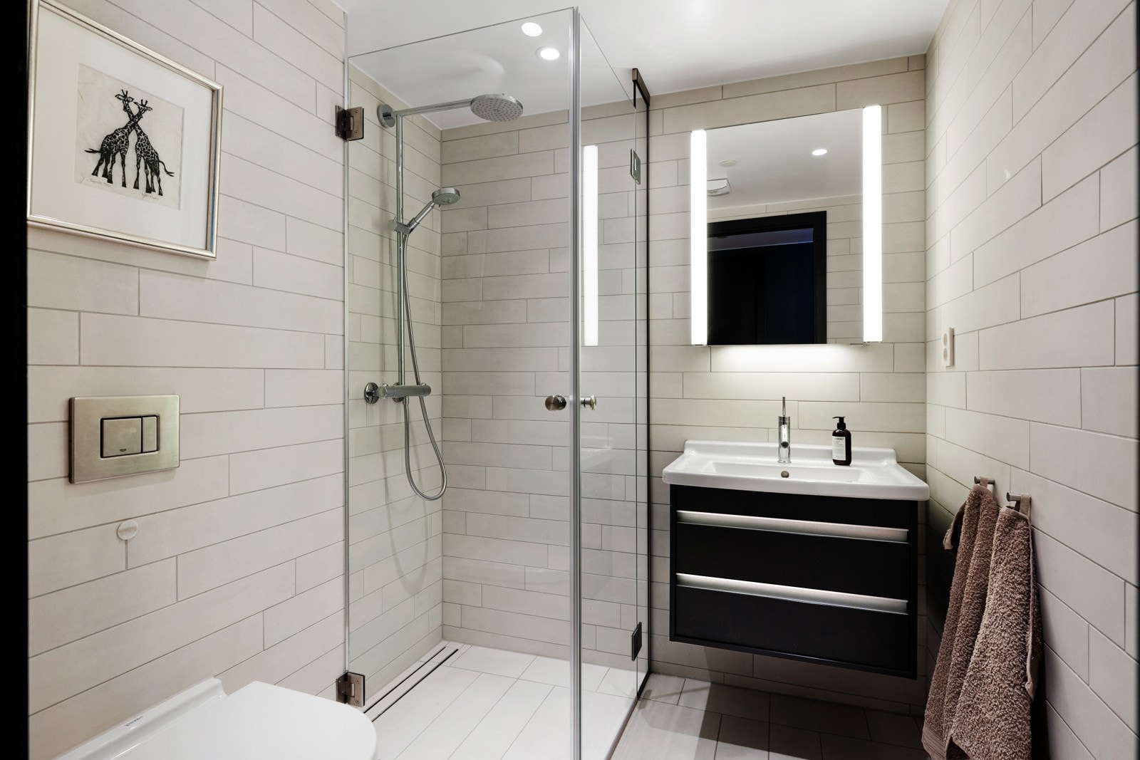 Det andre badet har det samme delikate uttrykket, med lyse fliser på både gulv og vegger. Begge badene sikrer komfort året rundt med elektrisk gulvvarme, balansert ventilasjon og downlightsbelysning Galleribilde