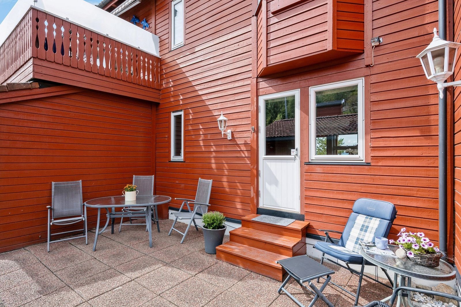 Utgang til østvendt, hellelagt uteplass med god plass til hagemøbler. Terrassen er er fellesareal men brukes i prinsipp kun av selger og naboene i nr. 8. Galleribilde