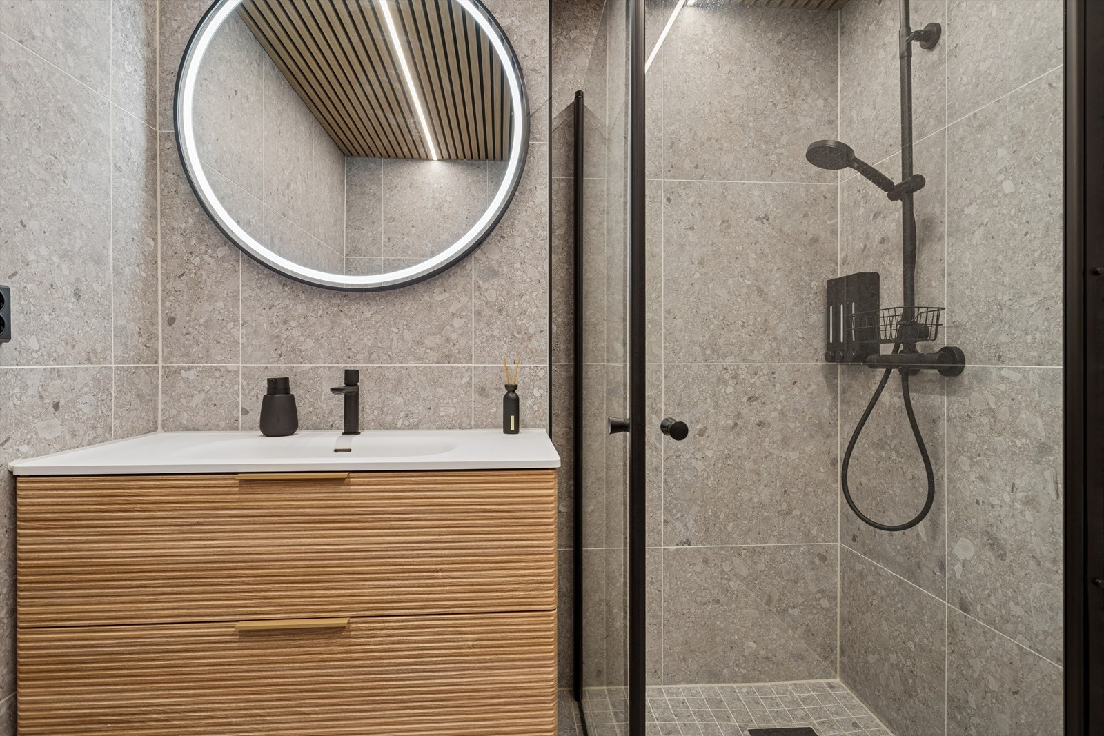 Baderommet er innredet med vegghengt toalett, innredning med servant. Åpen dusjsone med dusjgarnityr på vegg. Galleribilde