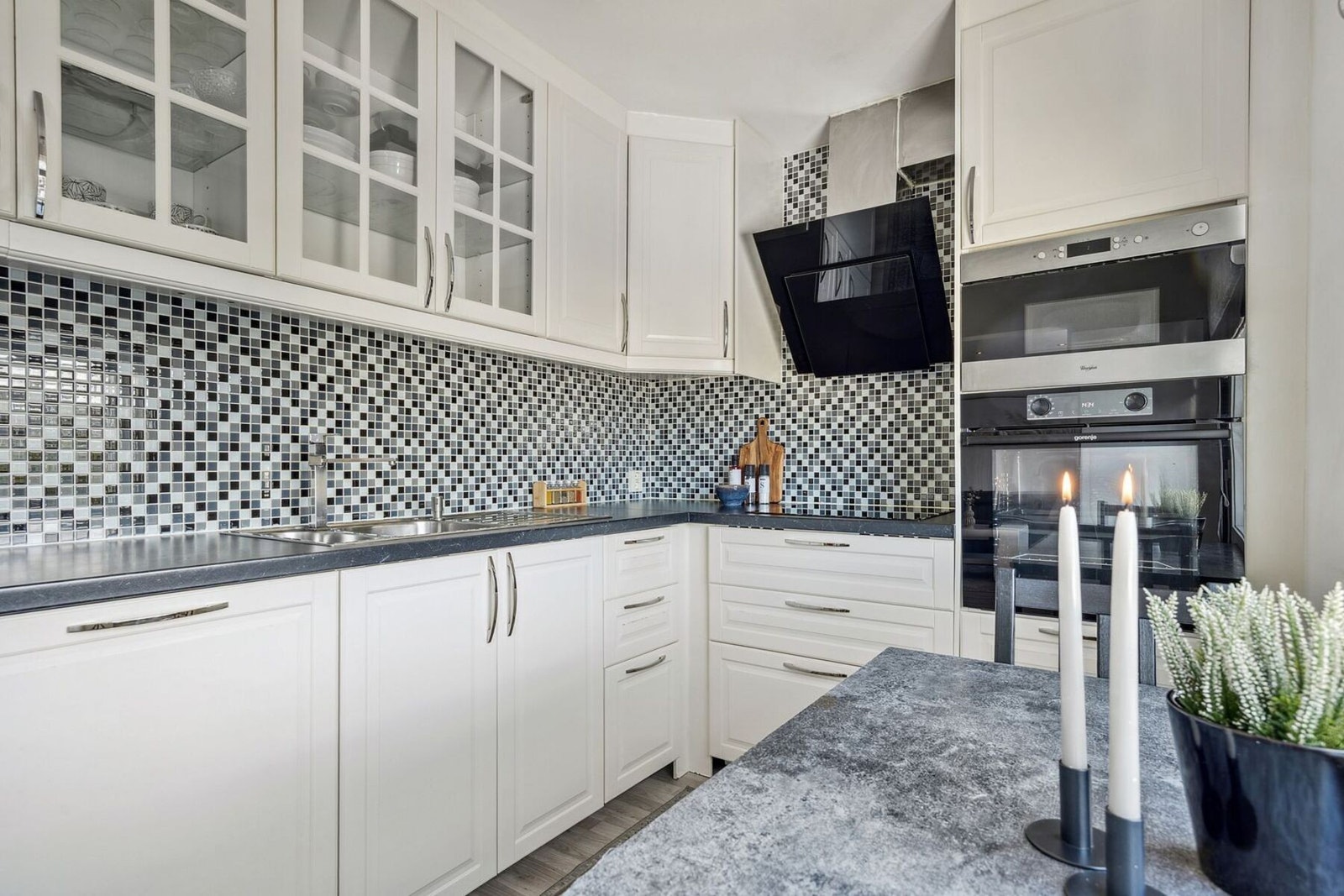 Her får du en gjennomført stil med hvite, tidløse fronter som gir et rent og elegant preg, kombinert med god benkeplass og rikelig med skap for oppbevaring. Galleribilde