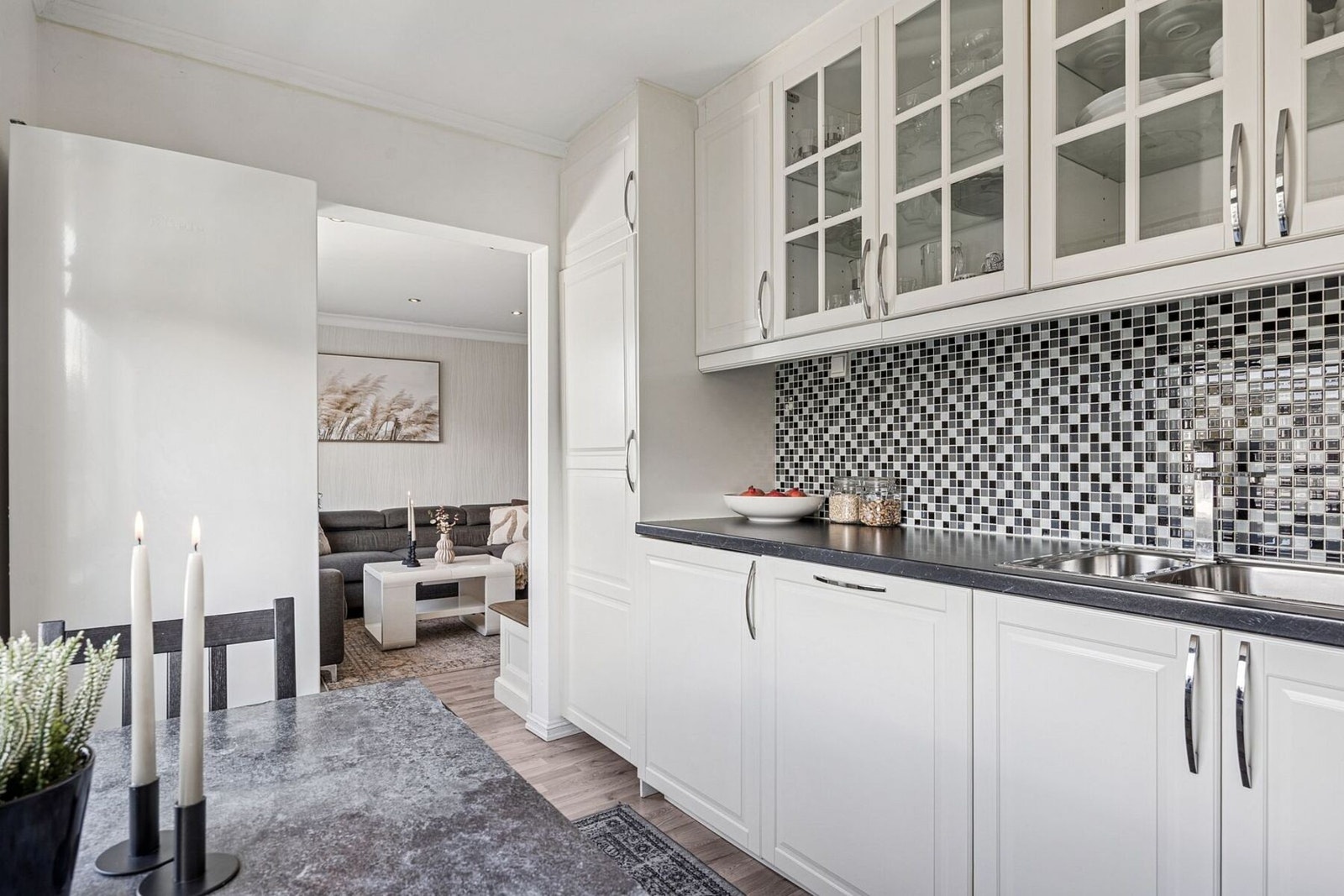 Kjøkkenet er utstyrt med integrerte hvitevarer, inkludert stekeovn, platetopp, oppvaskmaskin og mikroovn, som gir en helhetlig og moderne løsning. Galleribilde