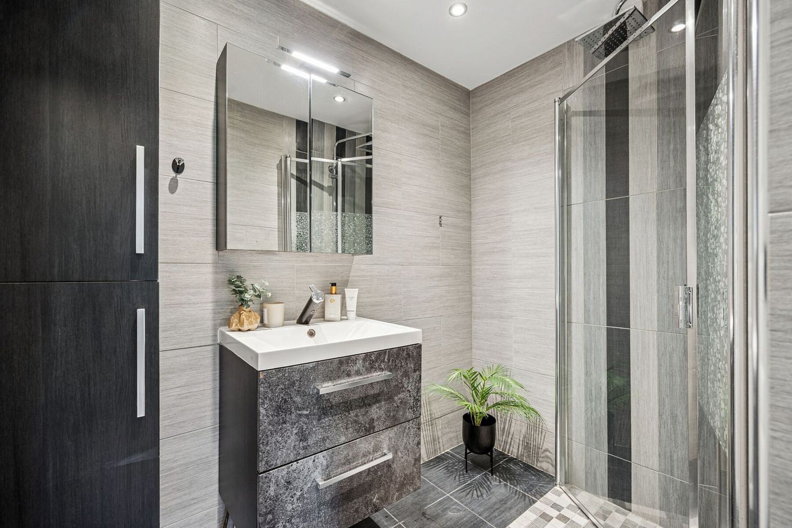 Boligen har et lekkert baderom med flislagte overflater, gulvvarme og innfelte downlights som gir et moderne preg. I tillegg finnes et separat toalettrom - en praktisk løsning som gjør hverdagen mer komfortabel. Galleribilde