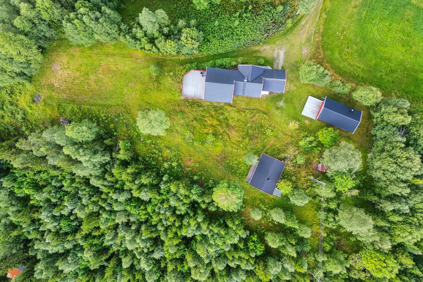 Oversiktsbilde. Tomt på totalt ca. 1 973m². Her får du en enebolig og to fritidsboliger beliggende på et høydedrag uten gjenboere. Galleribilde