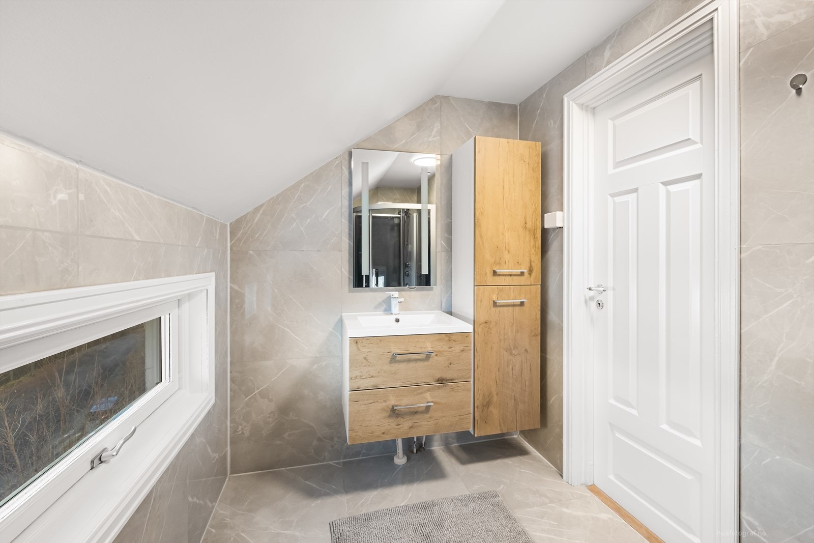 Badet i 2. etasje er pent og moderne innredet med lyse overflater og varme i gulv Galleribilde