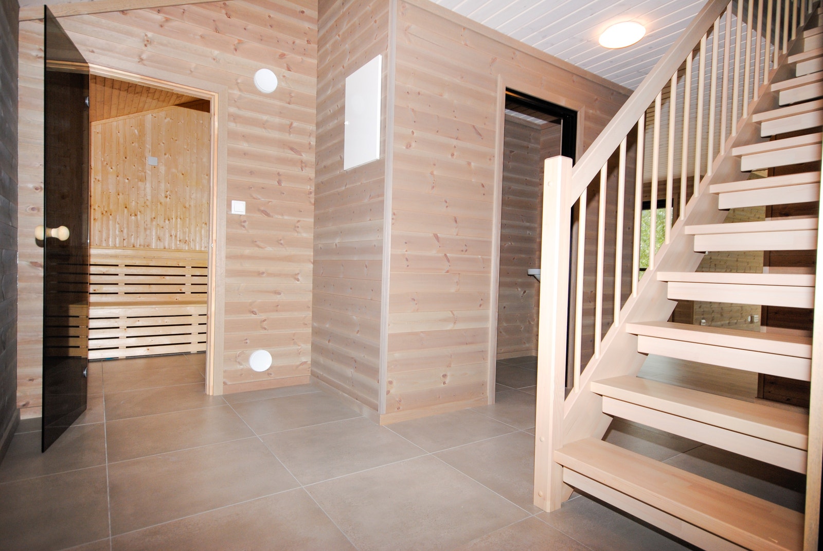 Badstu og gjestetoalett v entre. Her kan man springe inn og ut fra badstue til snø uten å bekymre seg for vått gulv. Galleribilde