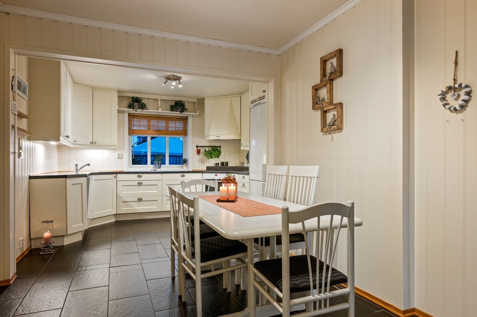 Kjøkkenet har innredning med profilerte fronter. Benkeplaten er av laminat - hyggelig med vindu ut mot bakhagen. Galleribilde