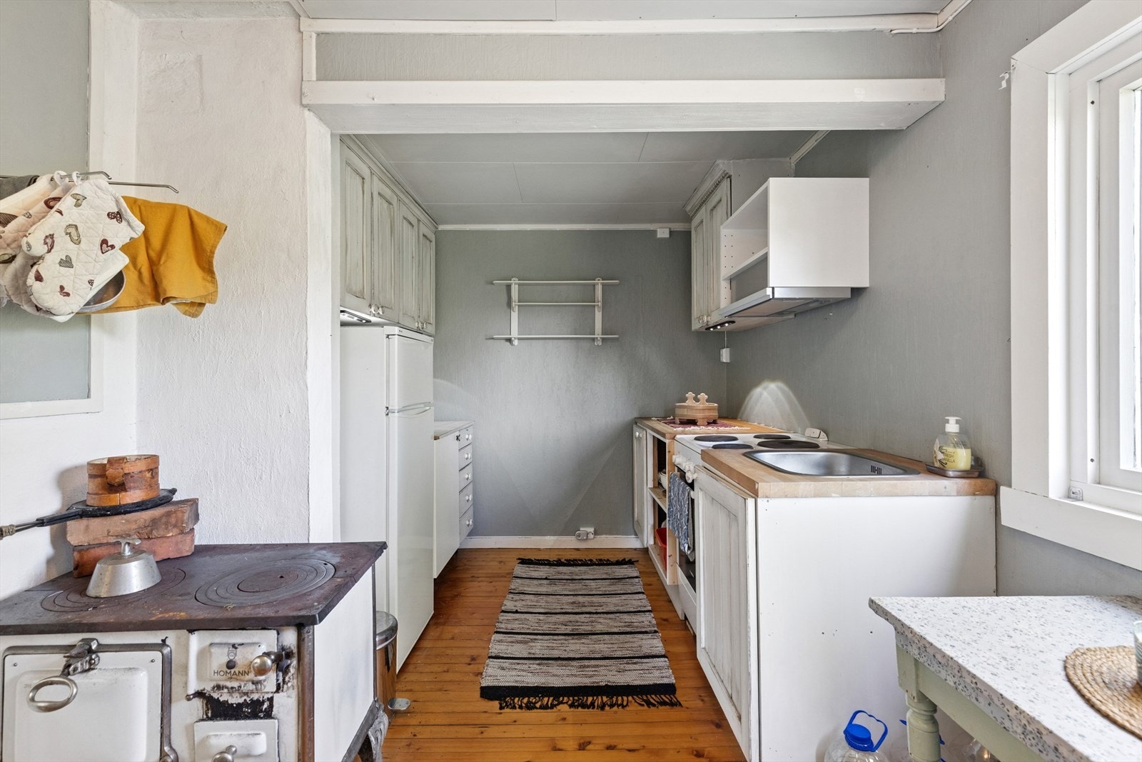 Det er en eldre, vedfyrt komfyr på kjøkkenet. Denne er trolig fra byggeår. Galleribilde