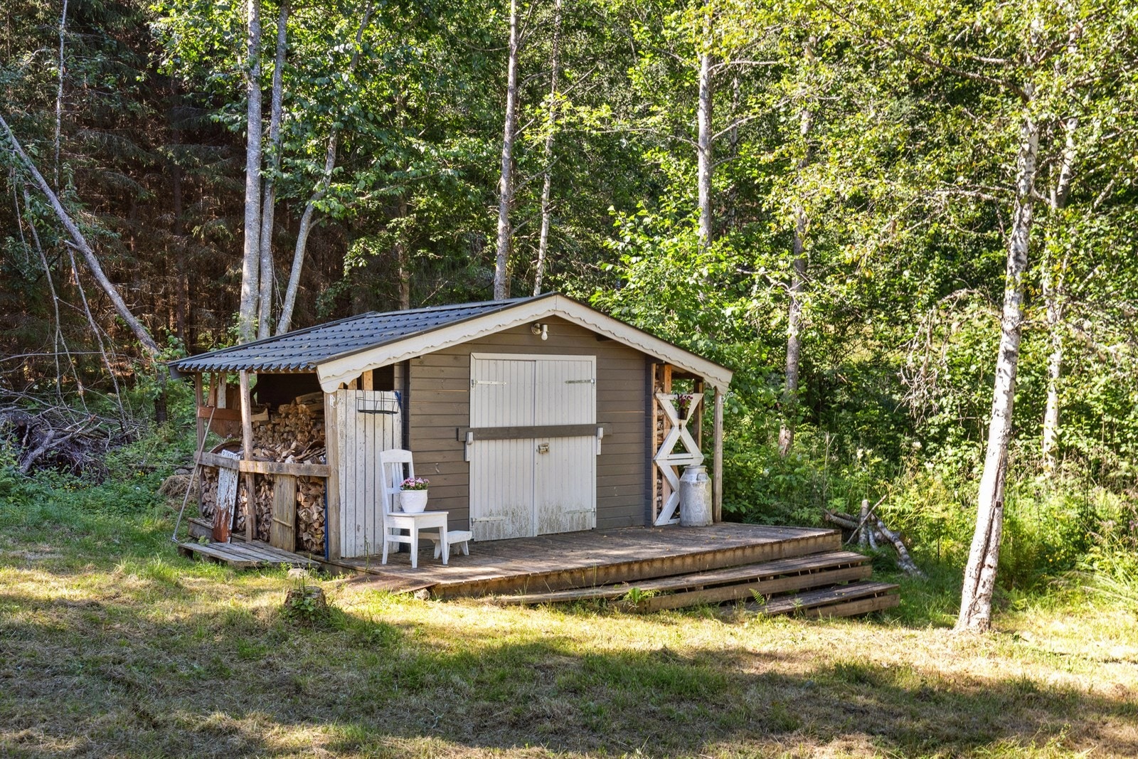 Romslig redskapsbod med platting i front. Galleribilde