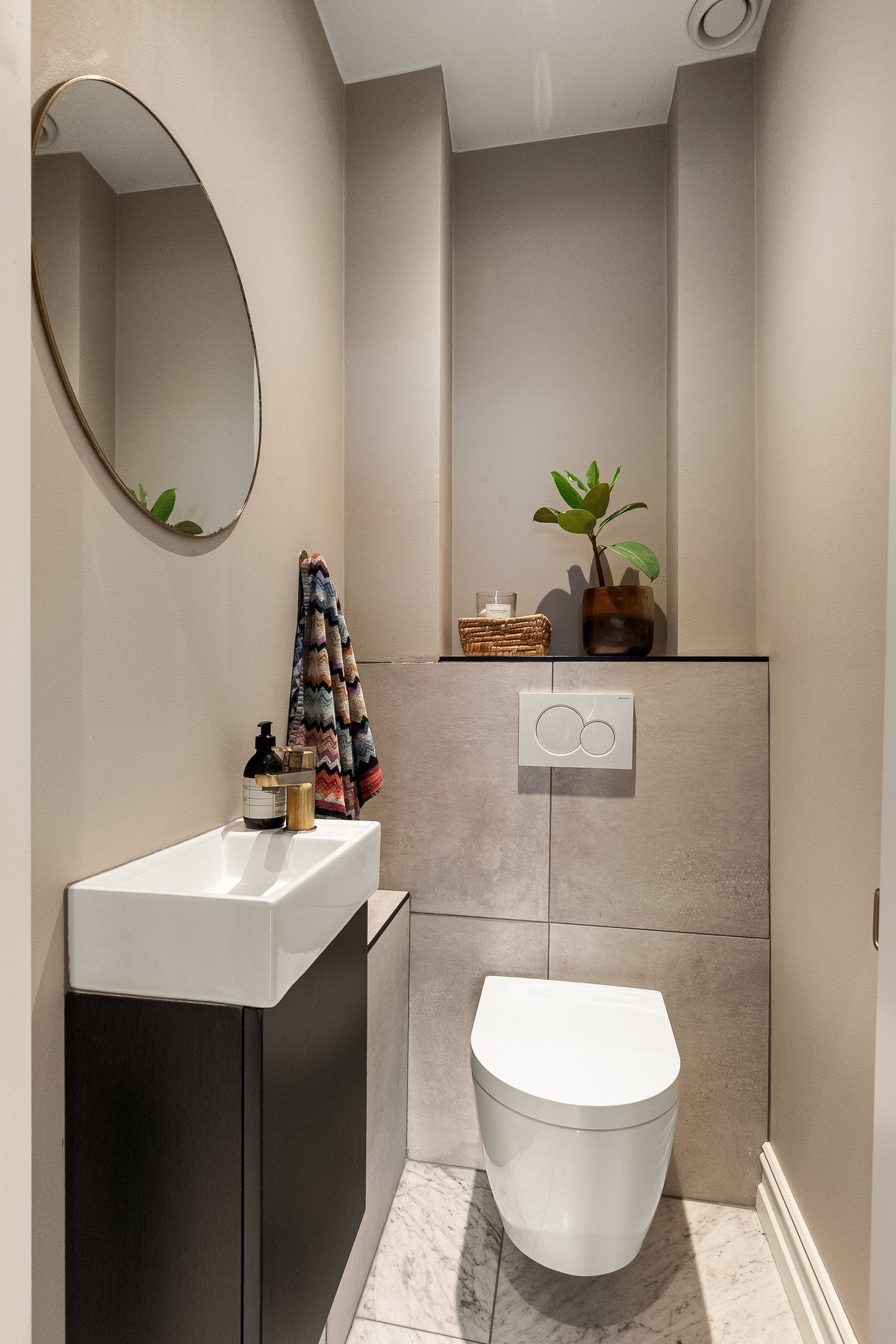 Natursteinsflisene av marmor gir et helhetlig uttrykk fra entré til toalettrom. Galleribilde