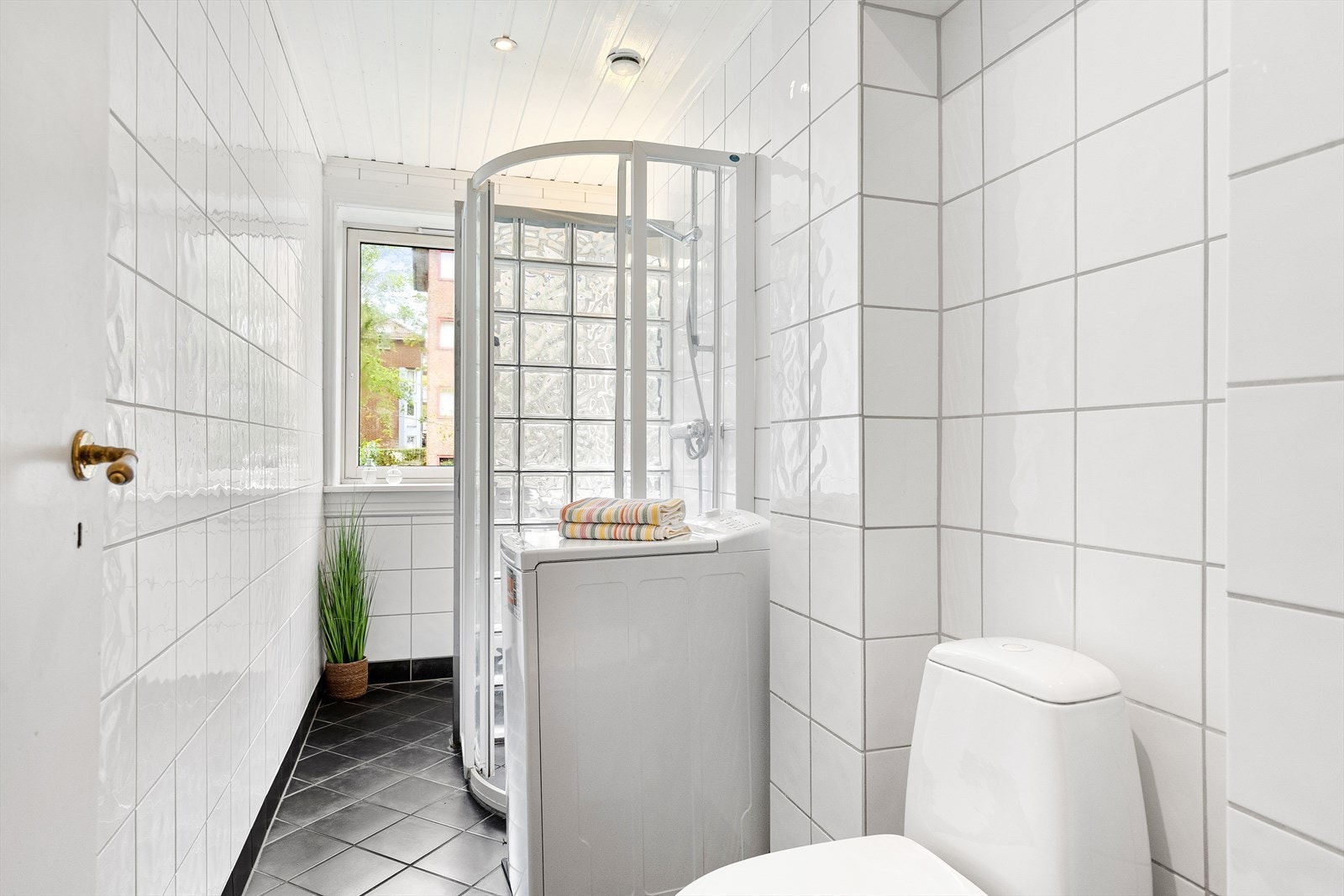 Badet er innredet med WC, dusj, servant med ettgreps blandebatteri i innredning, samt opplegg for vaskemaskin. Galleribilde