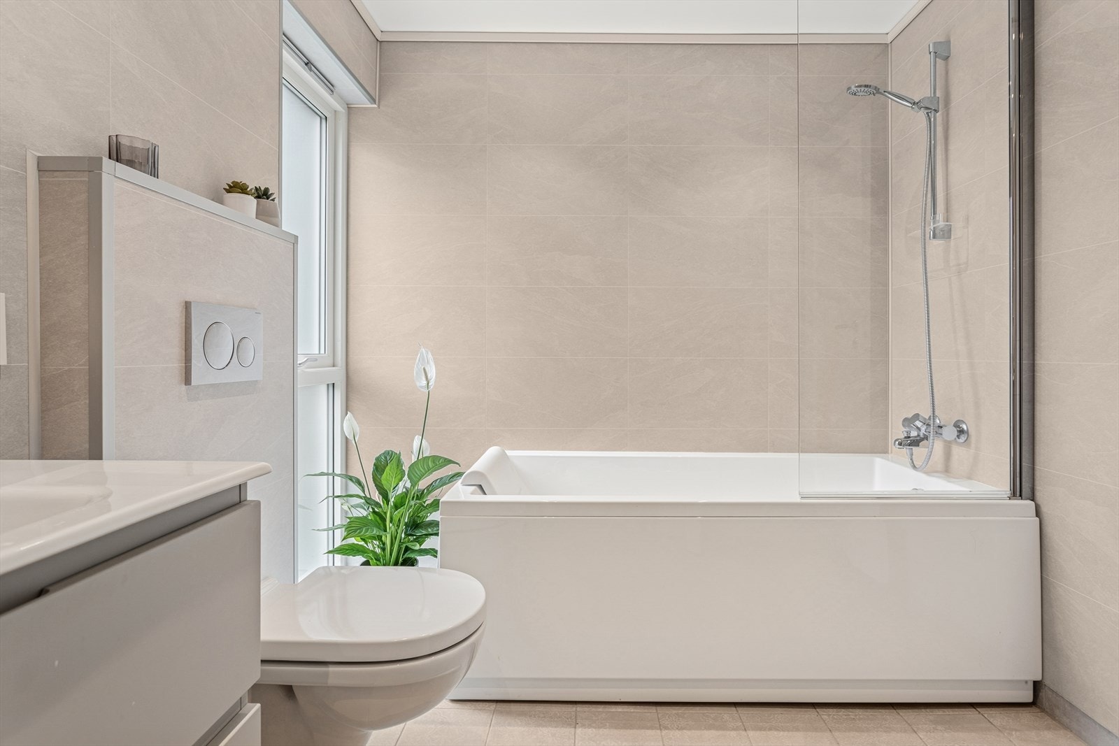 Eksklusivt baderom med stilrent design og en komfortabel dusj/badekar-løsning. Galleribilde