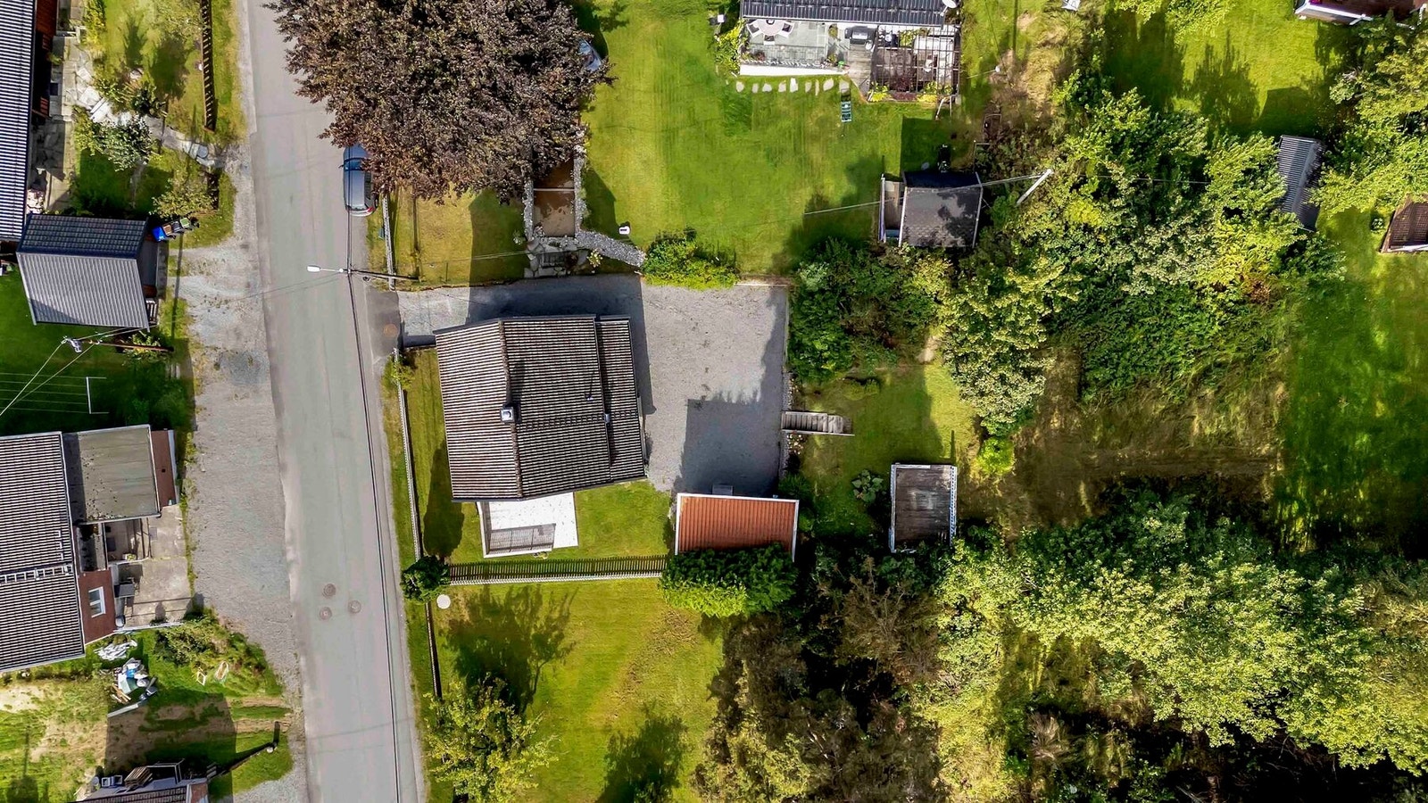 Fugleperspektiv over tomten som strekker seg helt til skoglinjen bakerst Galleribilde