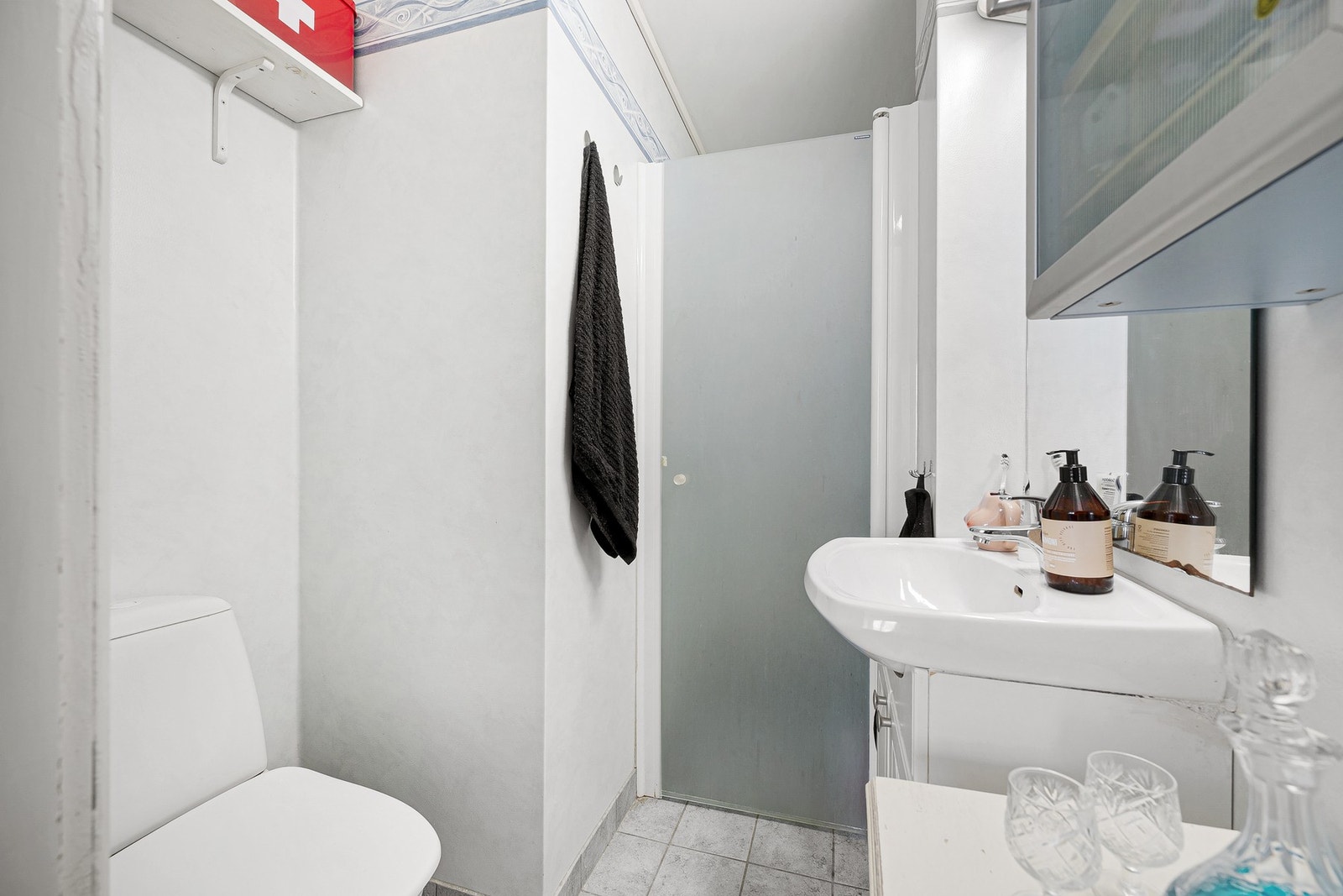 Lyst baderom med dusjløsning, servant og toalett. Galleribilde