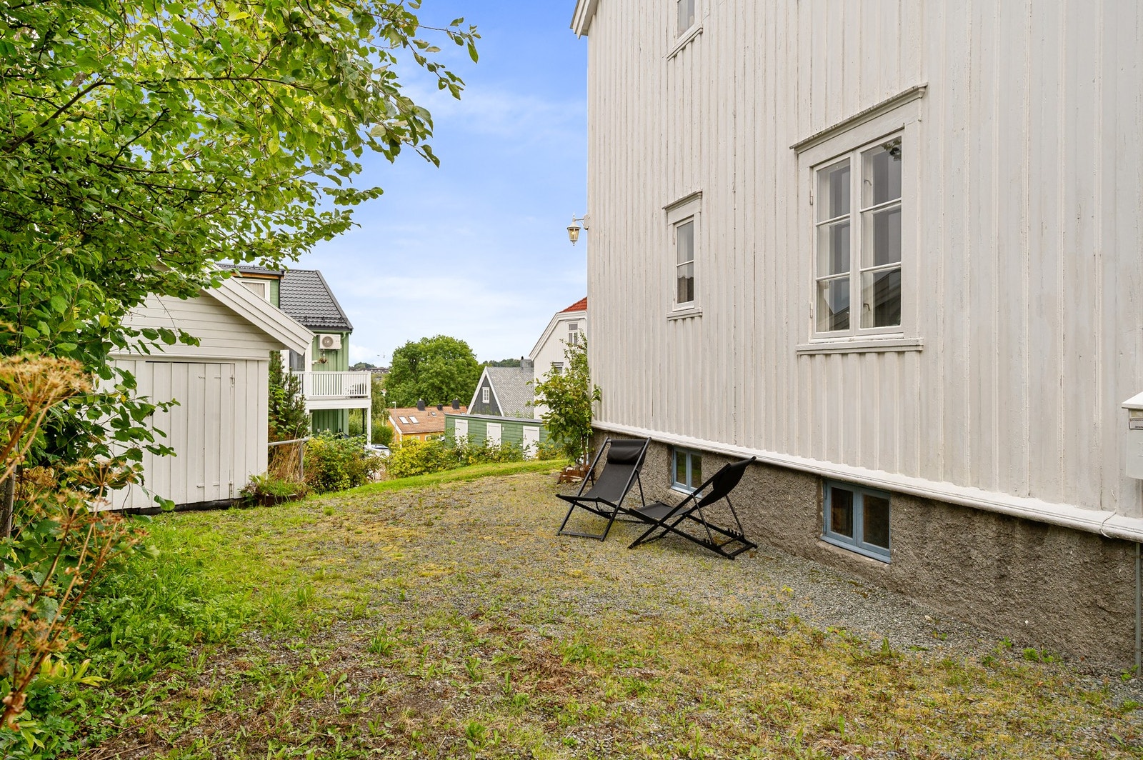 Eiendommen har en romslig tomt på over 900 kvadratmeter med plen, frukttrær og busker. Galleribilde