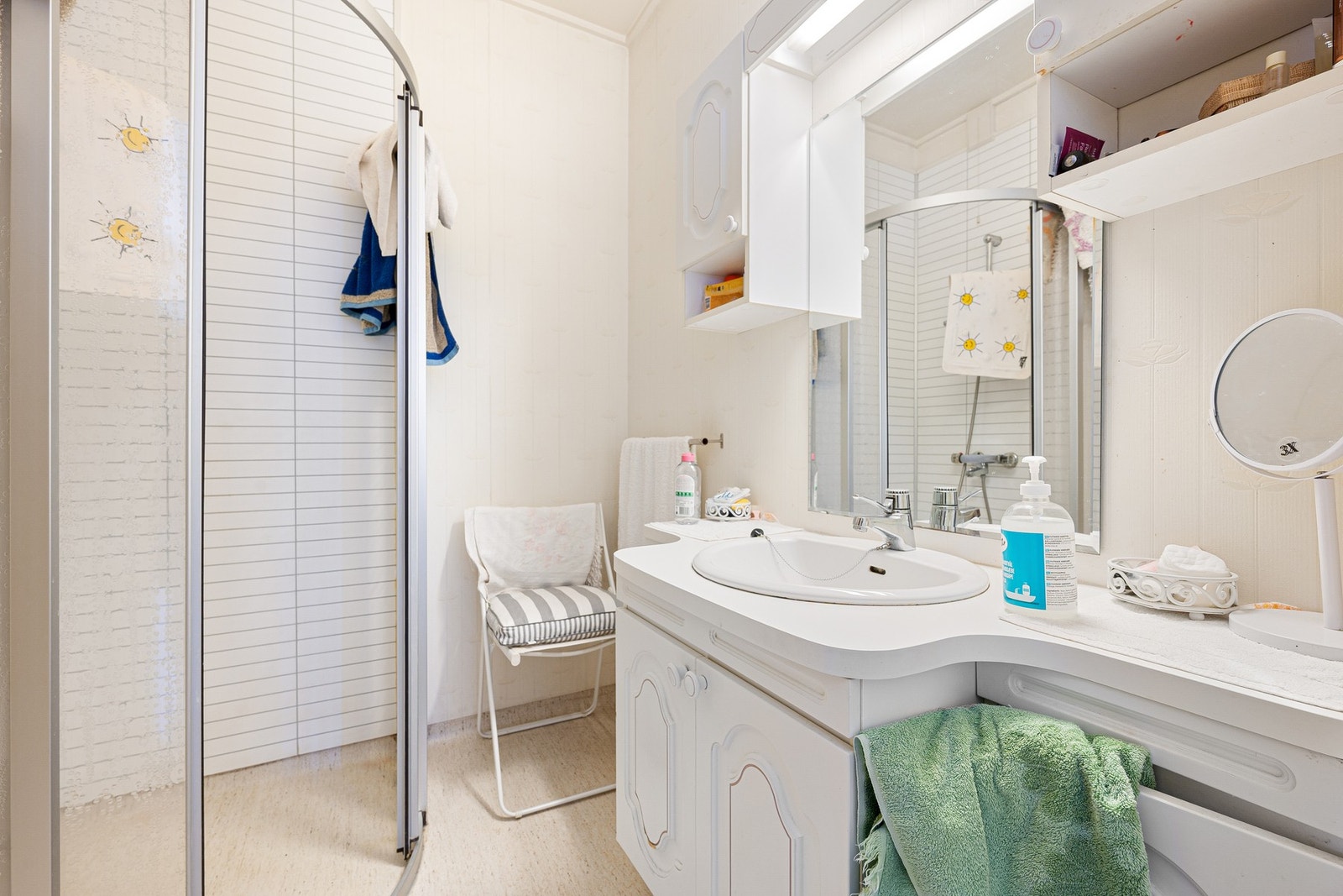 Bad med dusjhjørne, servantinnredning og speilskap. Galleribilde