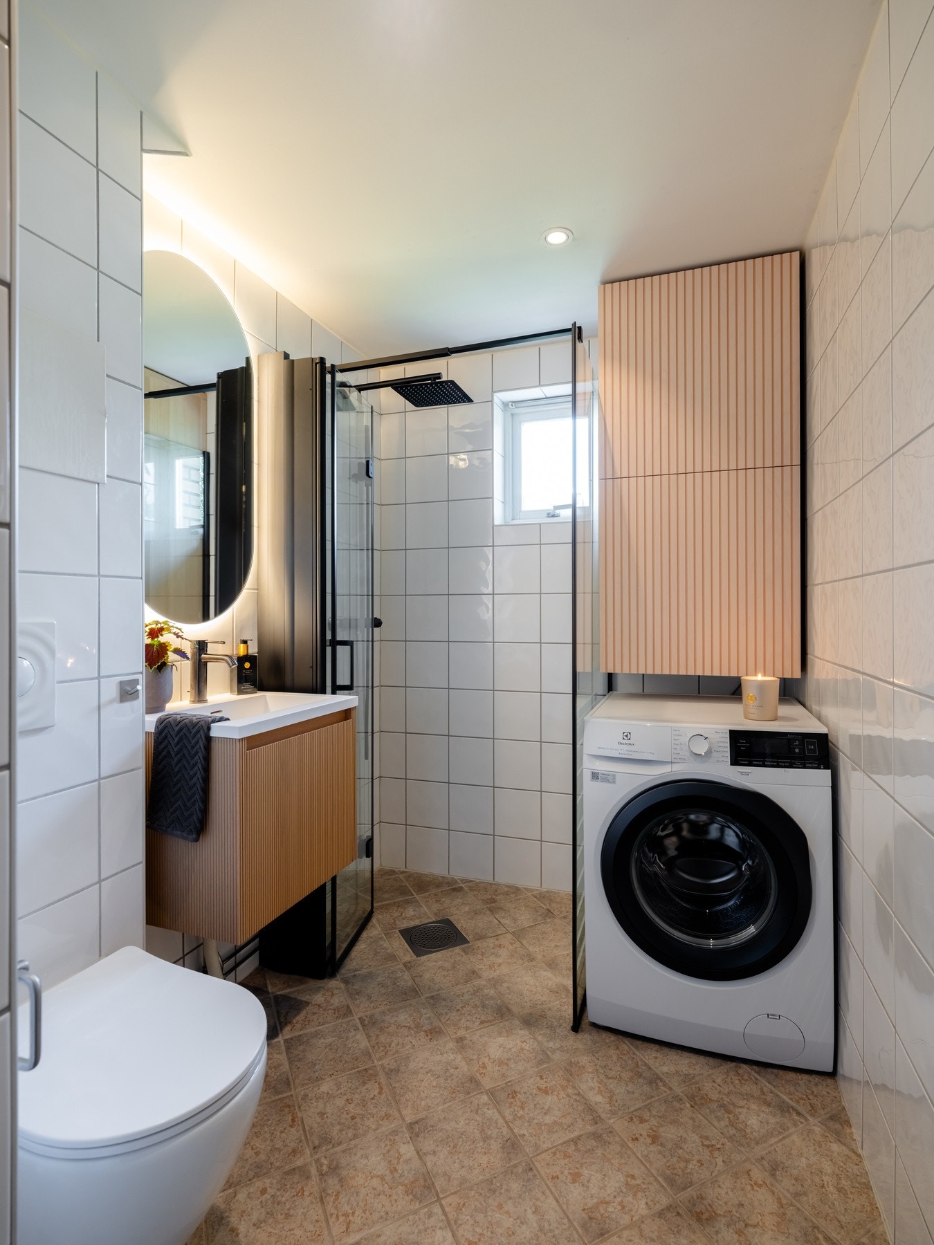 Videre er det vegghengt toalett og dusjhjørne med svingbar glassdør. På badet er det opplegg for vaskemaskin. Galleribilde