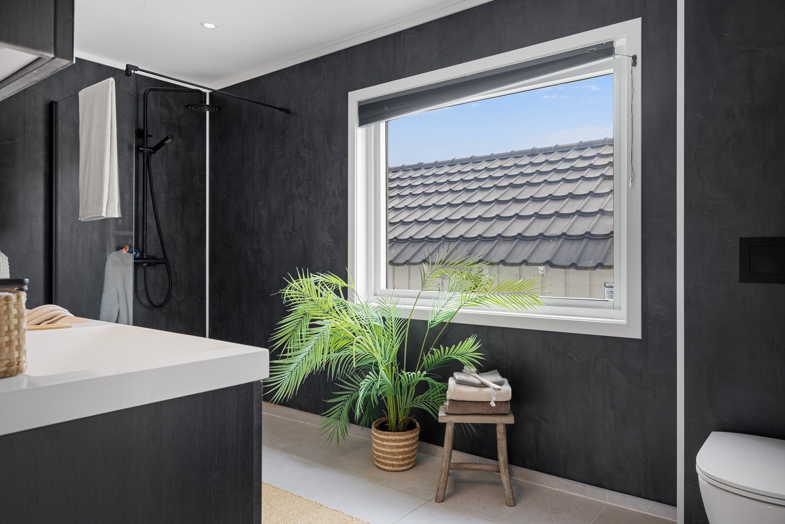 Badet har veggmontert toalett og opplegg for vaskemaskin. Galleribilde