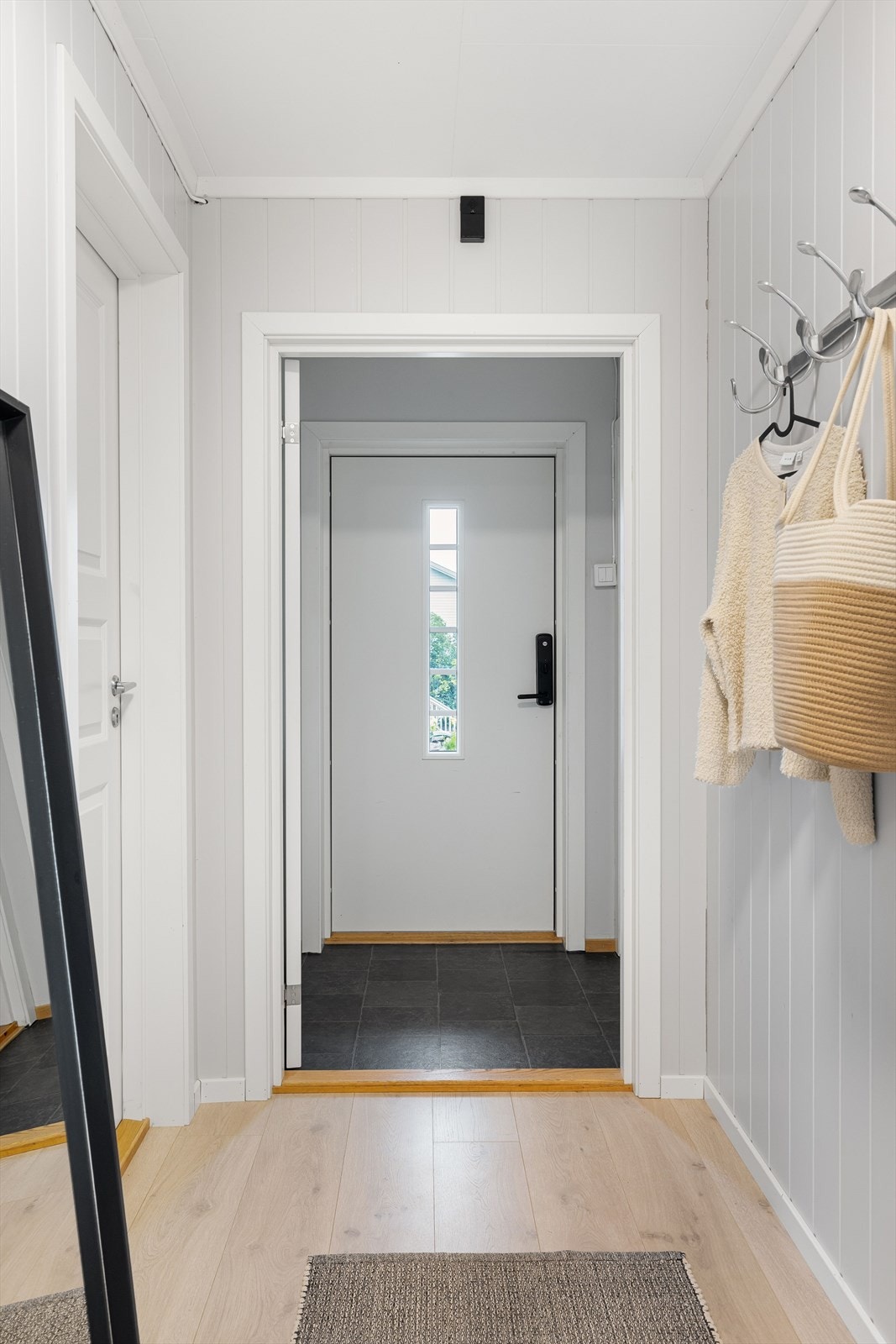 Boligens 1. etasje har et vindfang med trappegang til kjeller. Galleribilde