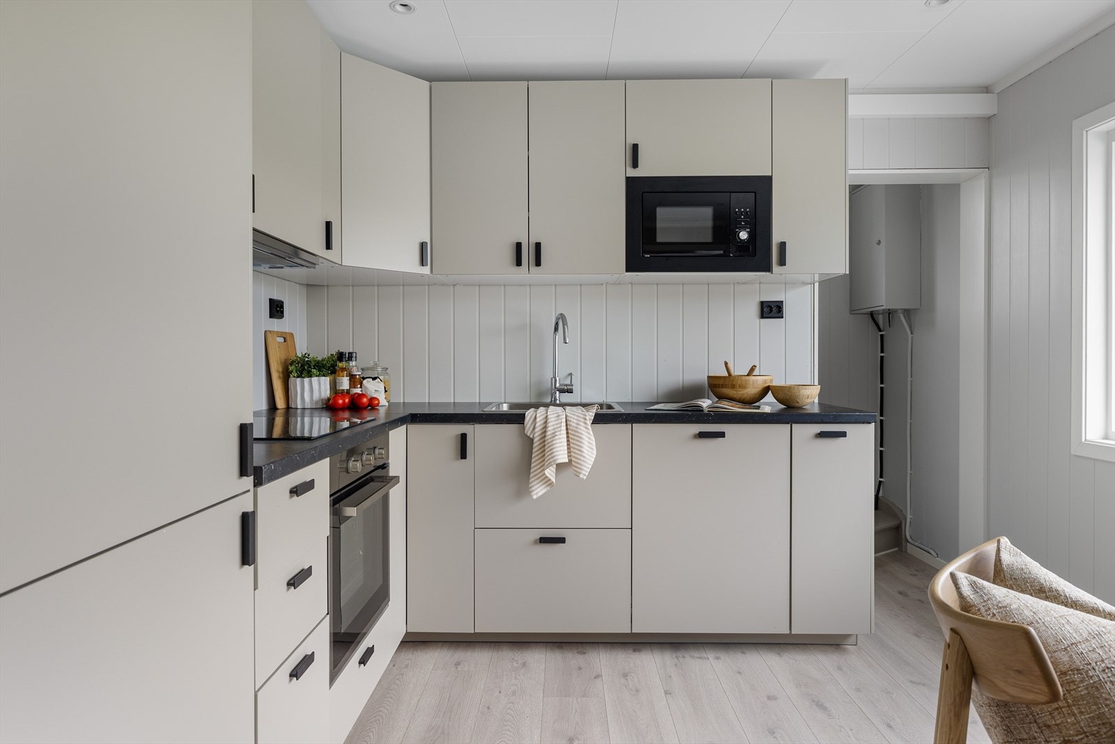 Innredningen har over- og underskap med glatte fronter og laminert benkeplate med nedfelt oppvaskum i rustfritt stål. Galleribilde