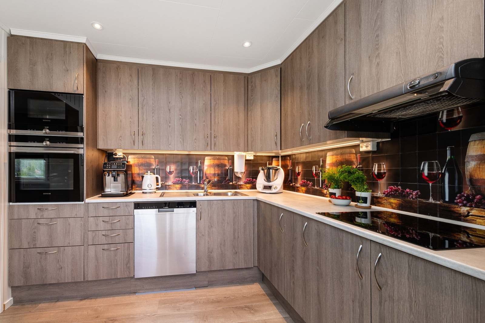 Det er integrert komfyr og mikrobølgeovn i høyskap, nedfelt induksjonstopp, samt avsatt plass til oppvaskmaskin og kjøleskap. Galleribilde