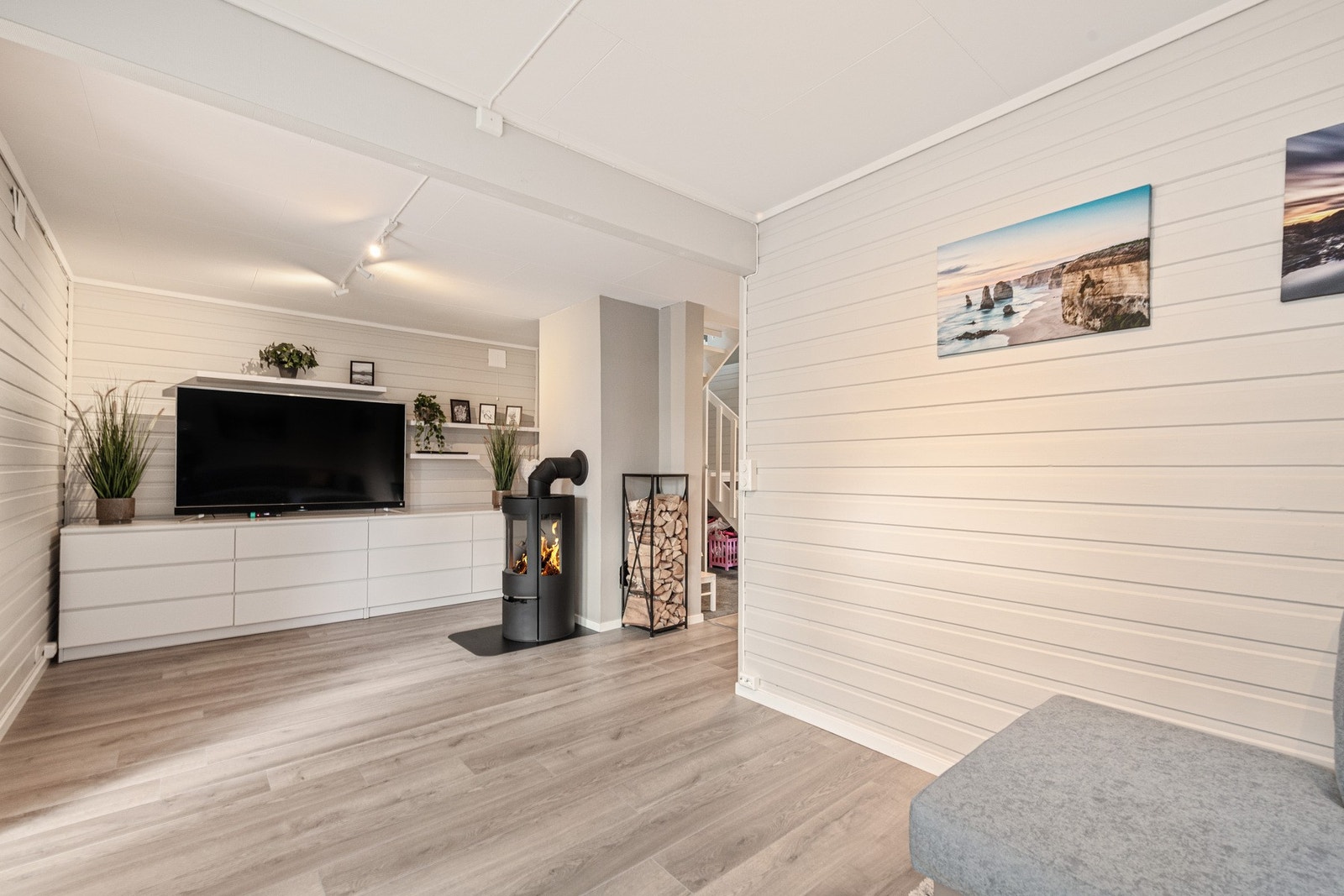 Romslig kjellerstue med god plass til TV-seksjon, sofagruppe og spisebord. Store vindusflater slipper inn rikelig med dagslys og gir fin utsikt mot hagen. Galleribilde