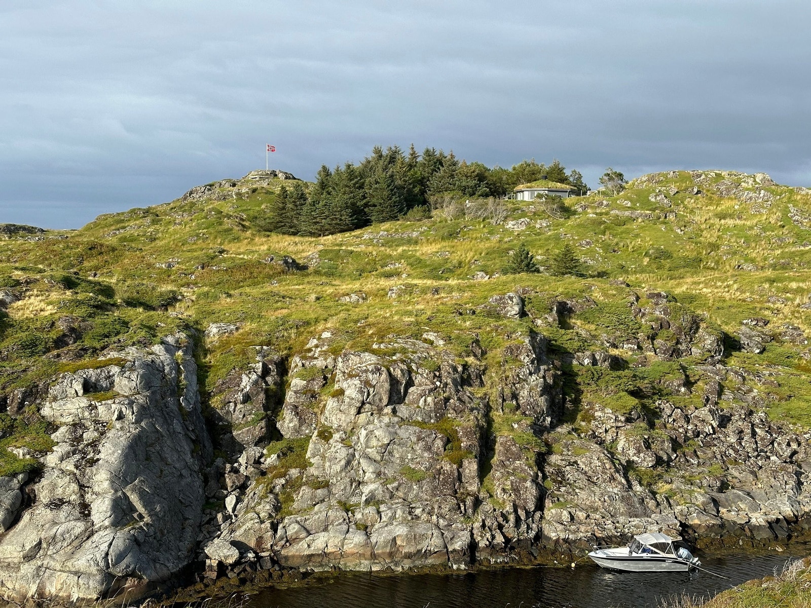 Båtplass i egen våg, bunker (ved flaggstangen) og hytte Galleribilde