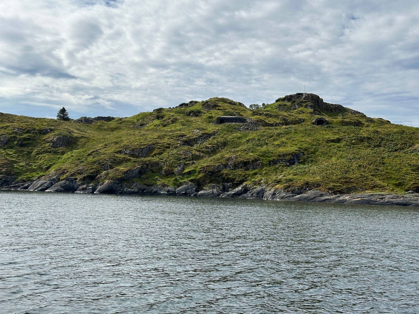 Den hemmelighetsfulle øyen (sett fra øst). Garasje til kanon eller kajakk nedenfor flaggstangen. Galleribilde