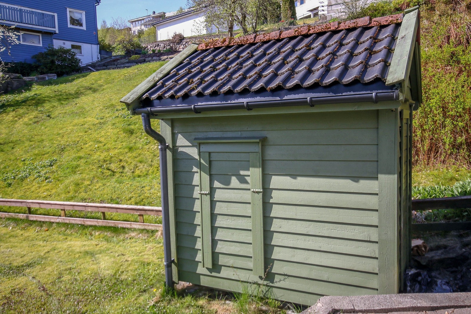 En utebod står på plenen. Kan brukes både til oppbevaring av hageutsyr og plenklipper. Galleribilde