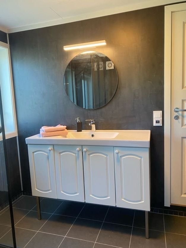 På badet nede er det rundt speil og 120cm baderomsmøbel. Galleribilde
