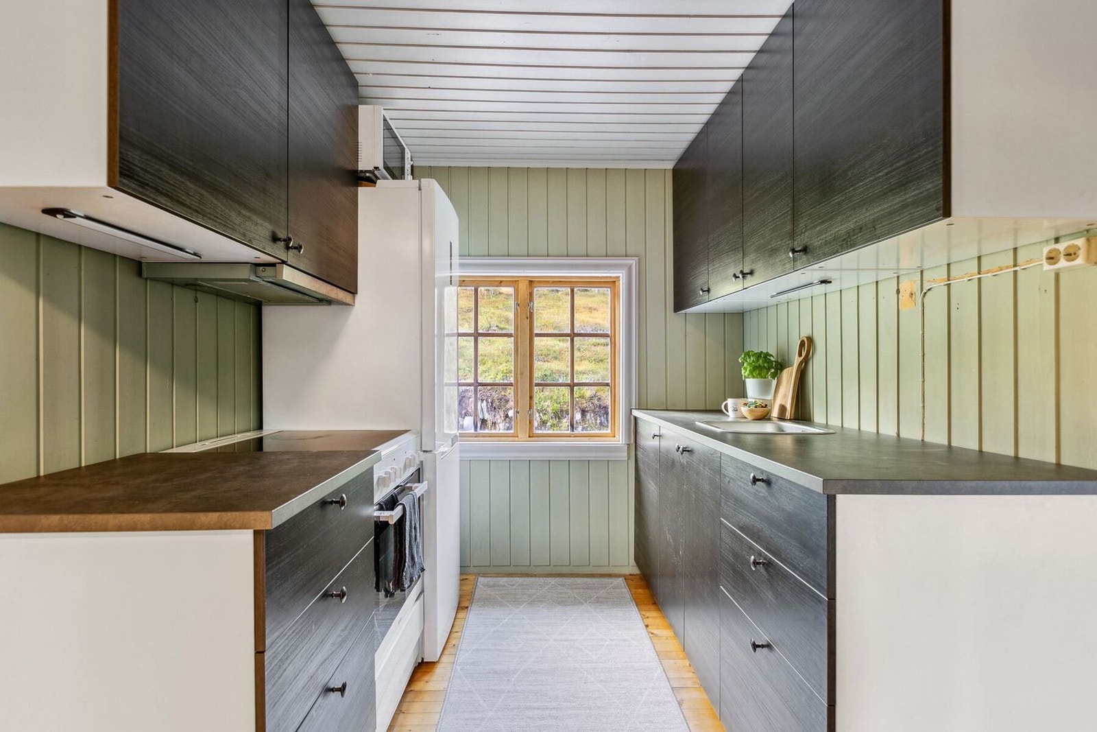 Pent kjøkken fra IKEA med glatte fronter og benkeplate av laminat. Kjøkkenet har fått TG1 i tilstandsrapport fra takstmann. Galleribilde