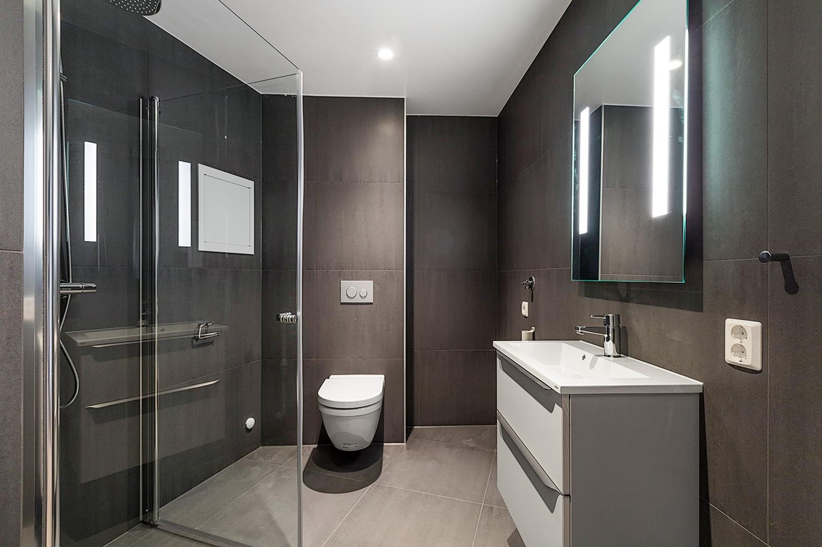 Flott bad med opplegg for vaskemaskin og varmekabler. Galleribilde