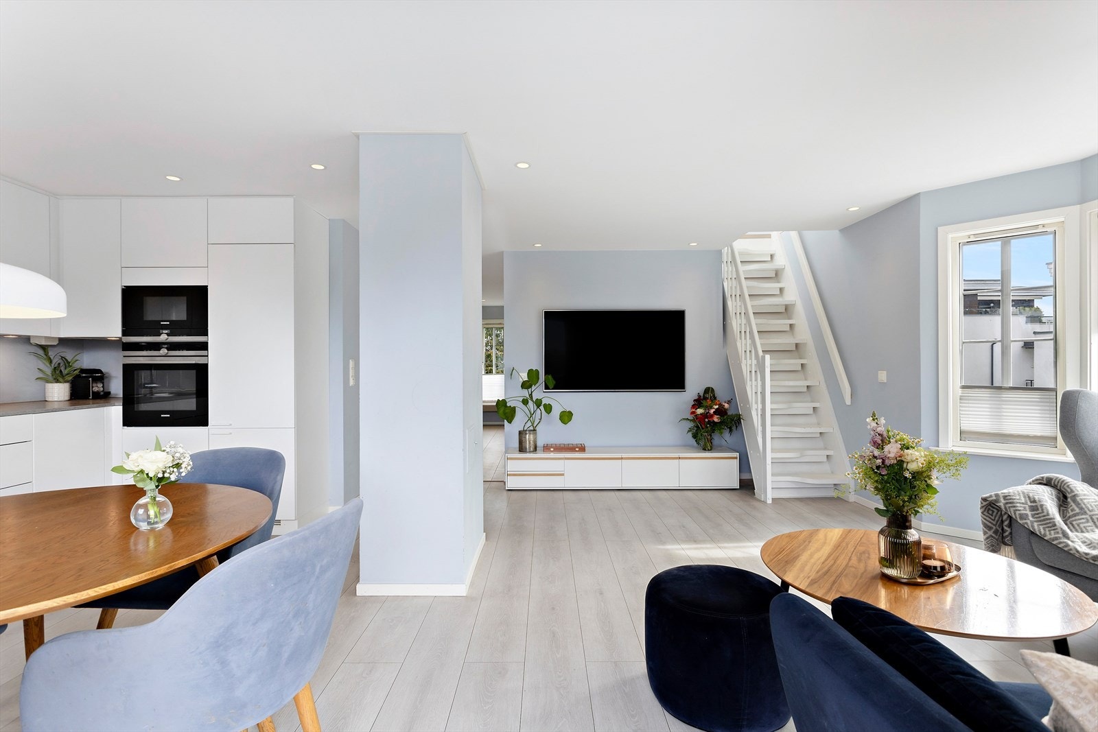 Rommet har en praktisk og moderne åpen løsning mot kjøkkenet, noe som gir gode muligheter for både sosiale soner og effektiv arealutnyttelse. Galleribilde