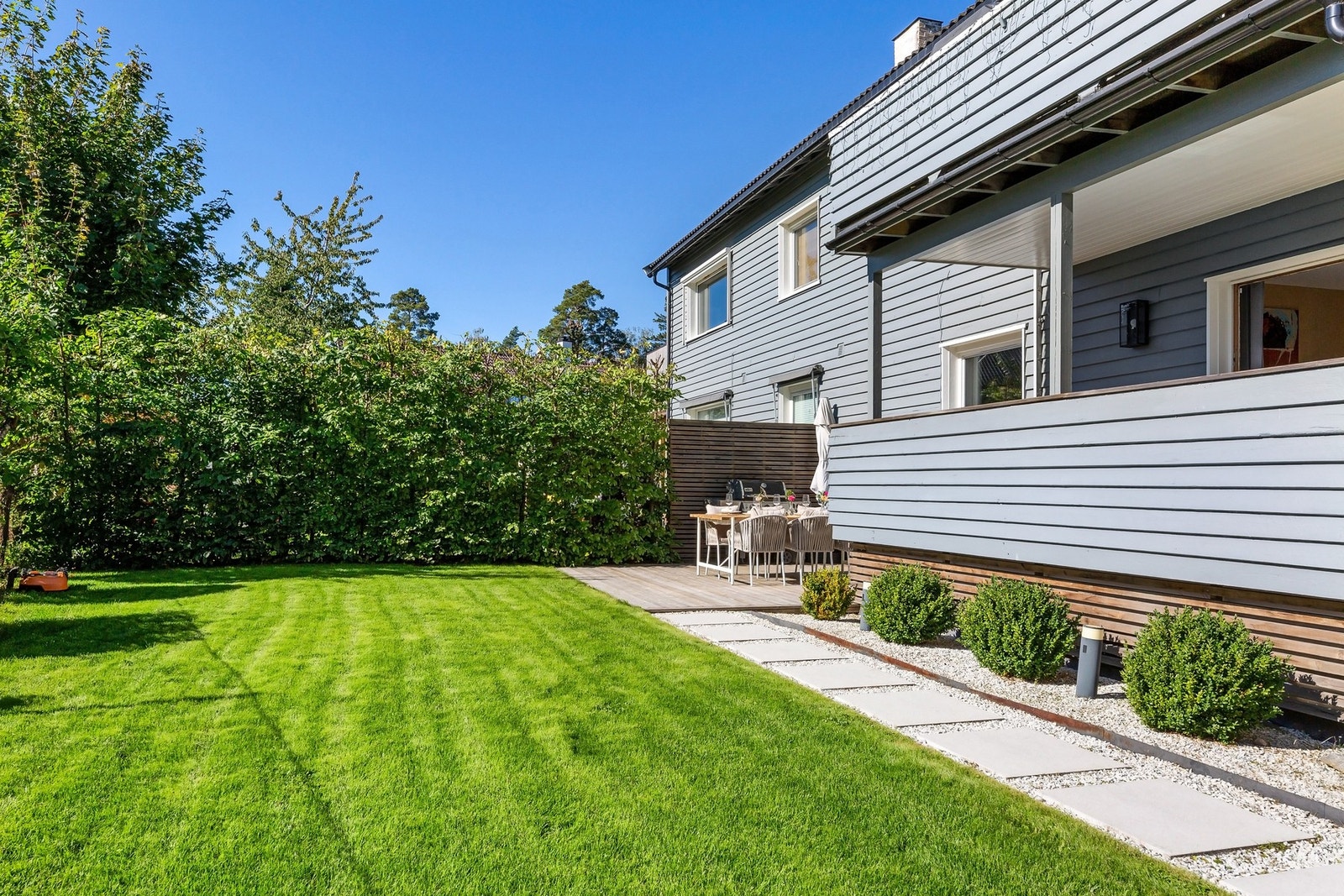Hagen er ryddig og pent opparbeidet med gressplen, steinheller og naturstein Galleribilde