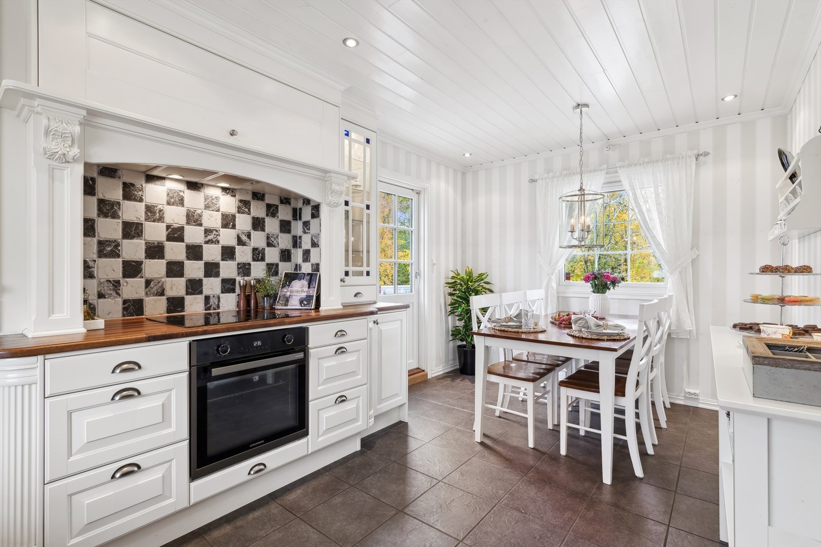 Det er rikelig med arbeidsoner og oppbevaringsplass da det er montert godt med over- og underskap, med innredning som strekker seg pent gjennom rommet. Galleribilde