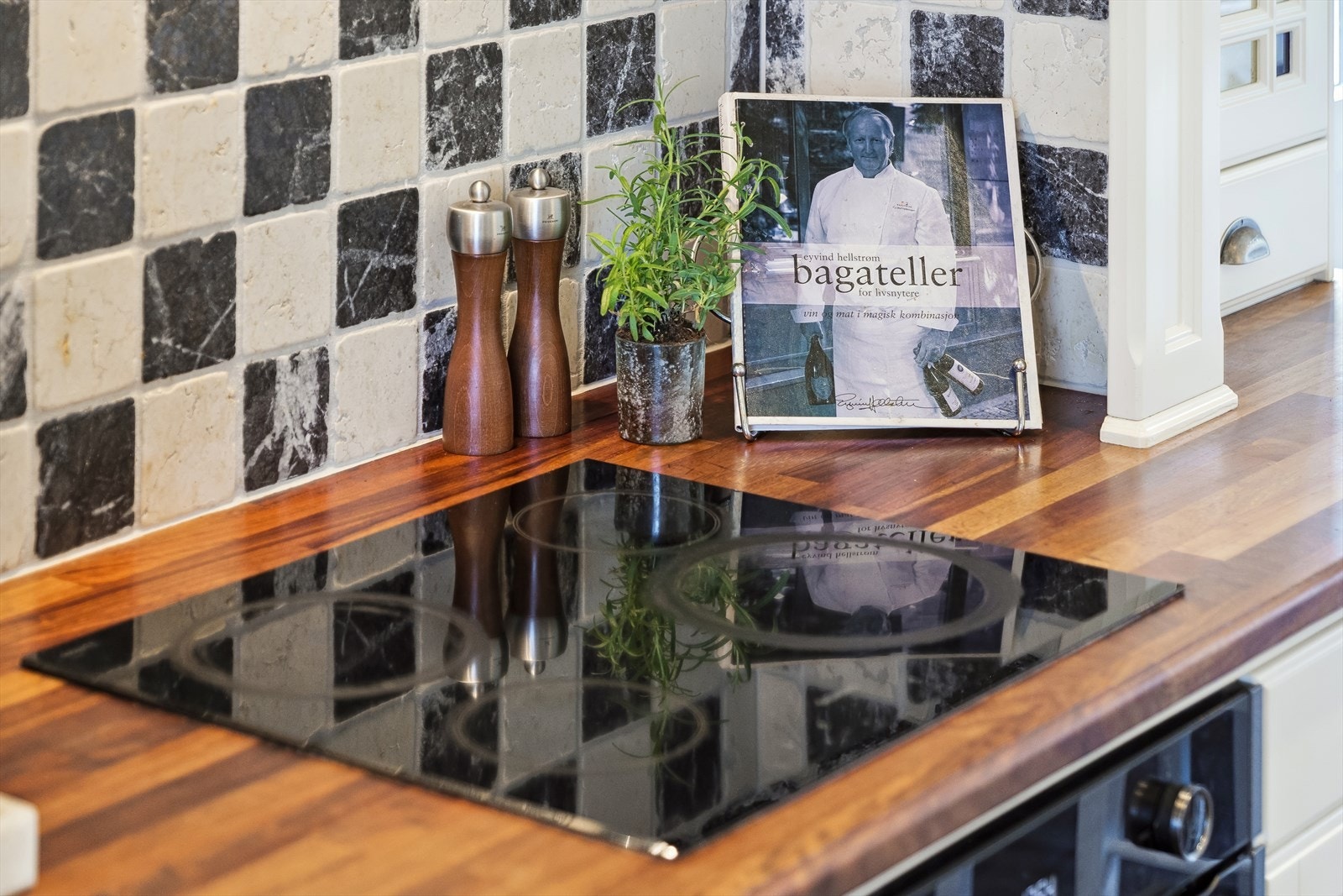 Kjøkkenet har fine detaljer som spotbelysning i taket, flislagt gulv m/varmekabler, integrerte hvitevarer (nytt kjøleskap blir montert september 2025), flislagt sone mellom benkeplate og overskap og store vinduer som slipper inn godt med dagslys. Galleribilde