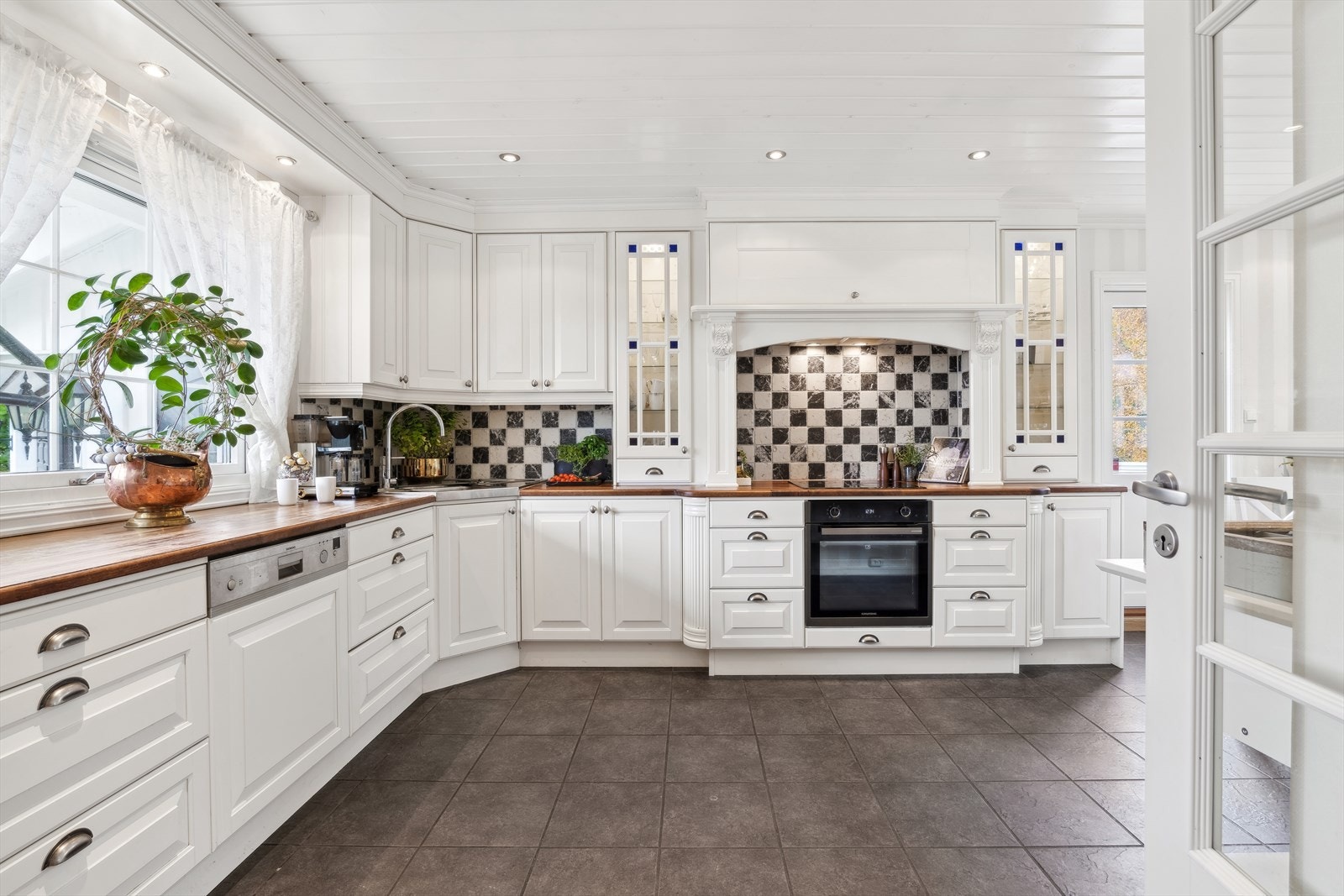 På kjøkkenet er det montert en klassisk, herskaplig og pen kjøkkeninnredning i en lys og tidløs utførelse med profiterte fronter og detaljer. Galleribilde