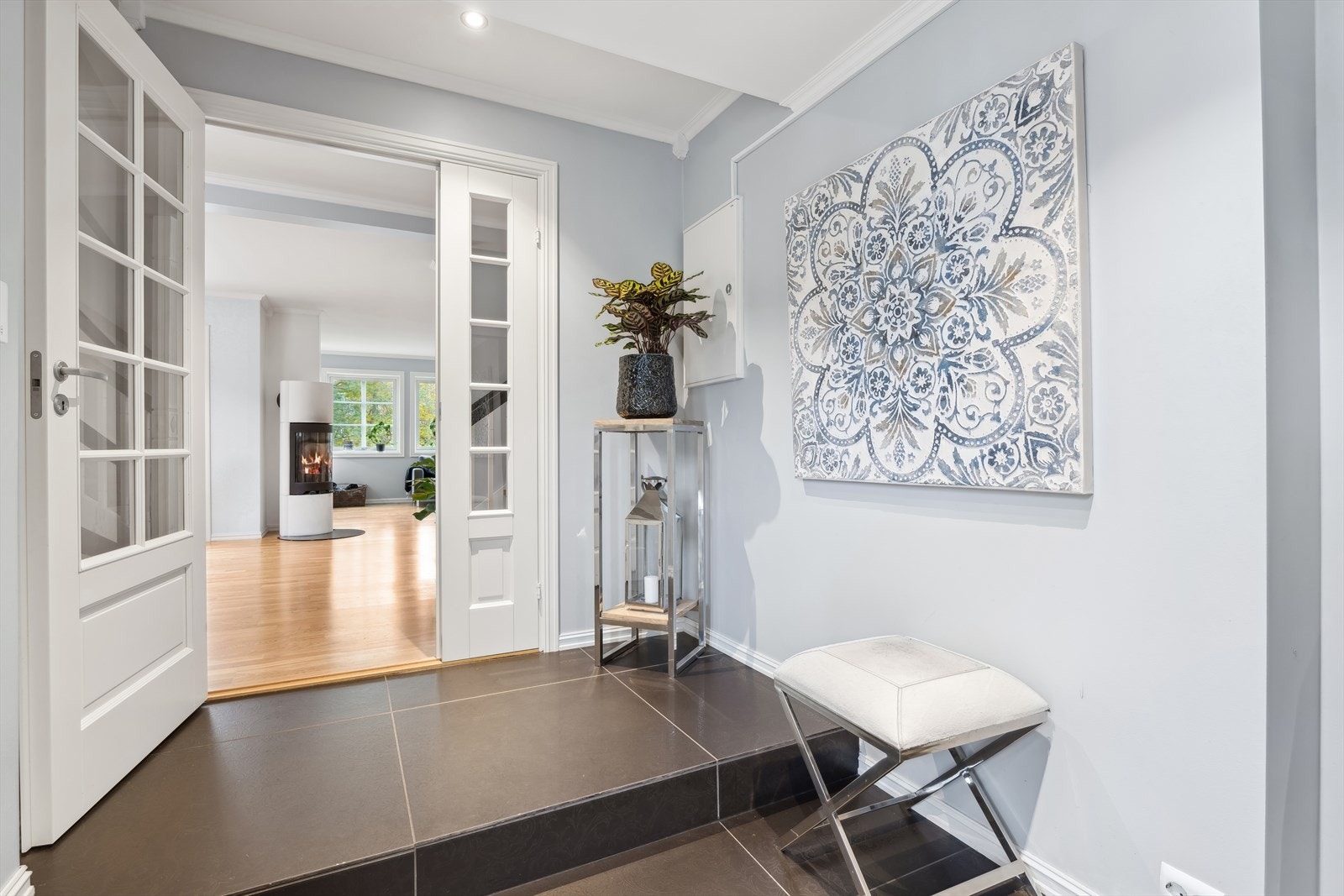 Gulvet er belagt med lekre, store og eksklusive fliser fra Versace, som harmonerer godt med den øvrige gjennomførelsen. Det er i tillegg behagelige varmekabler i gulvet. Hallen gjennomført i lyse og innbydende farger og har flotte detaljer. Galleribilde