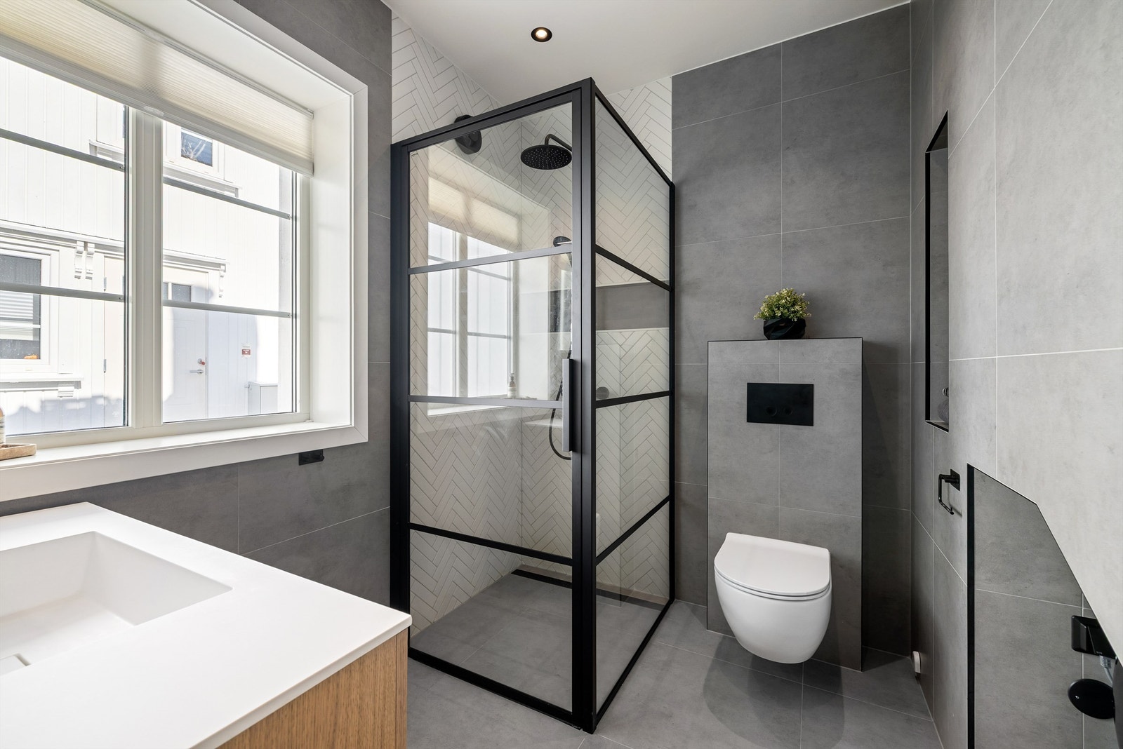 En vellykket kombinasjon av lekre fliser og moderne innredninger gir badet egenart. Dusjhjørnets armatur er integrert i vegg. Galleribilde