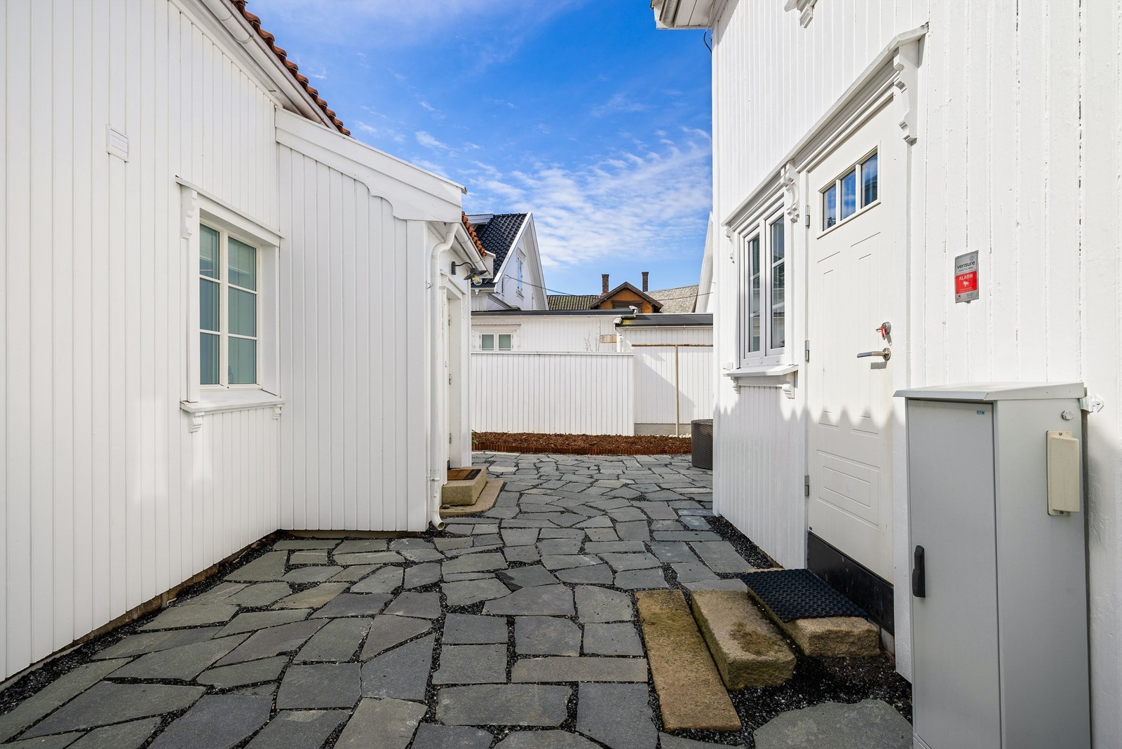 Adkomst til annekset skjer like innenfor porten, før hovedboligens inngangsparti og utearealer. Galleribilde