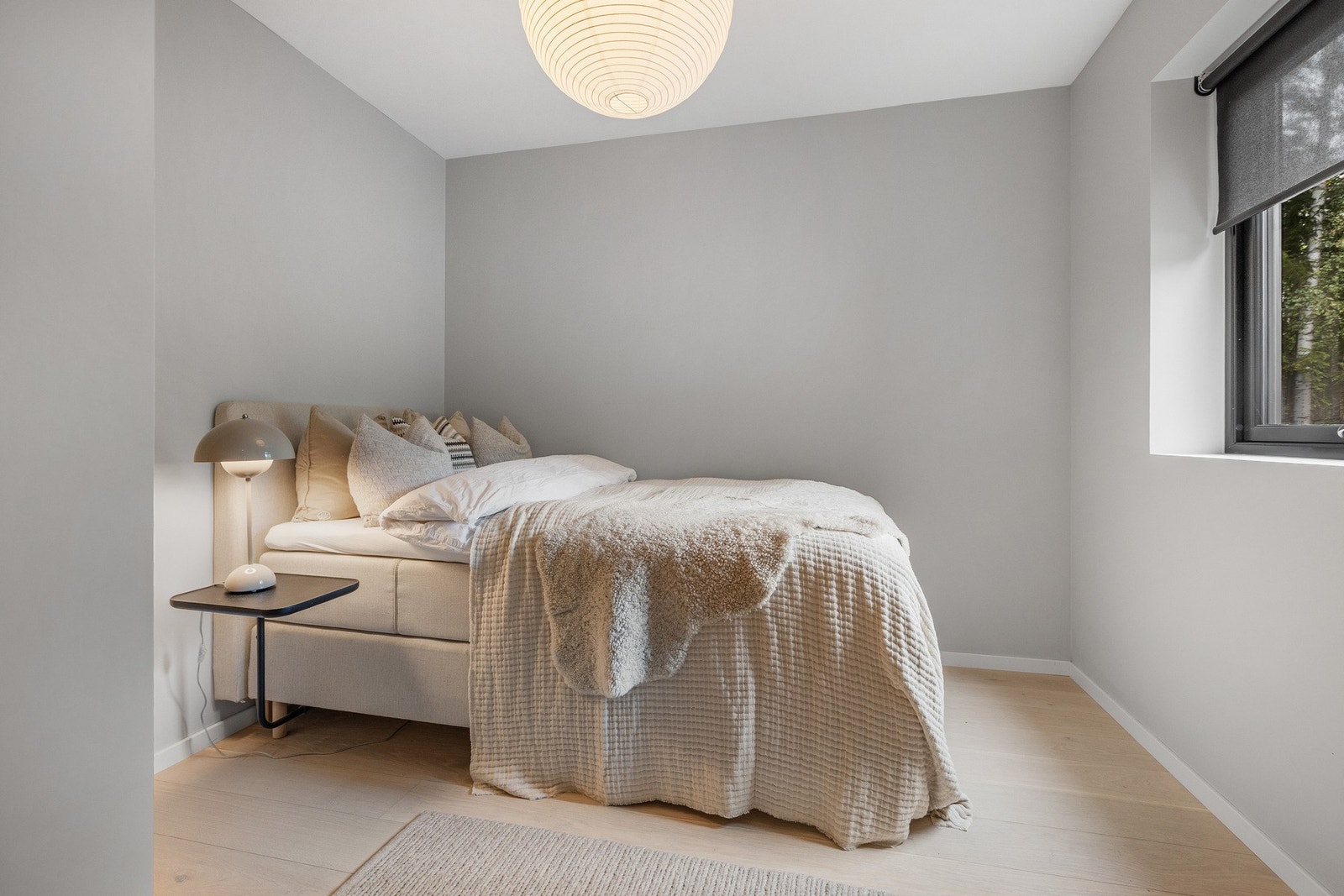 Innbydende soverom med lyse fargevalg og store vindusflater som gir godt med naturlig lys. Galleribilde