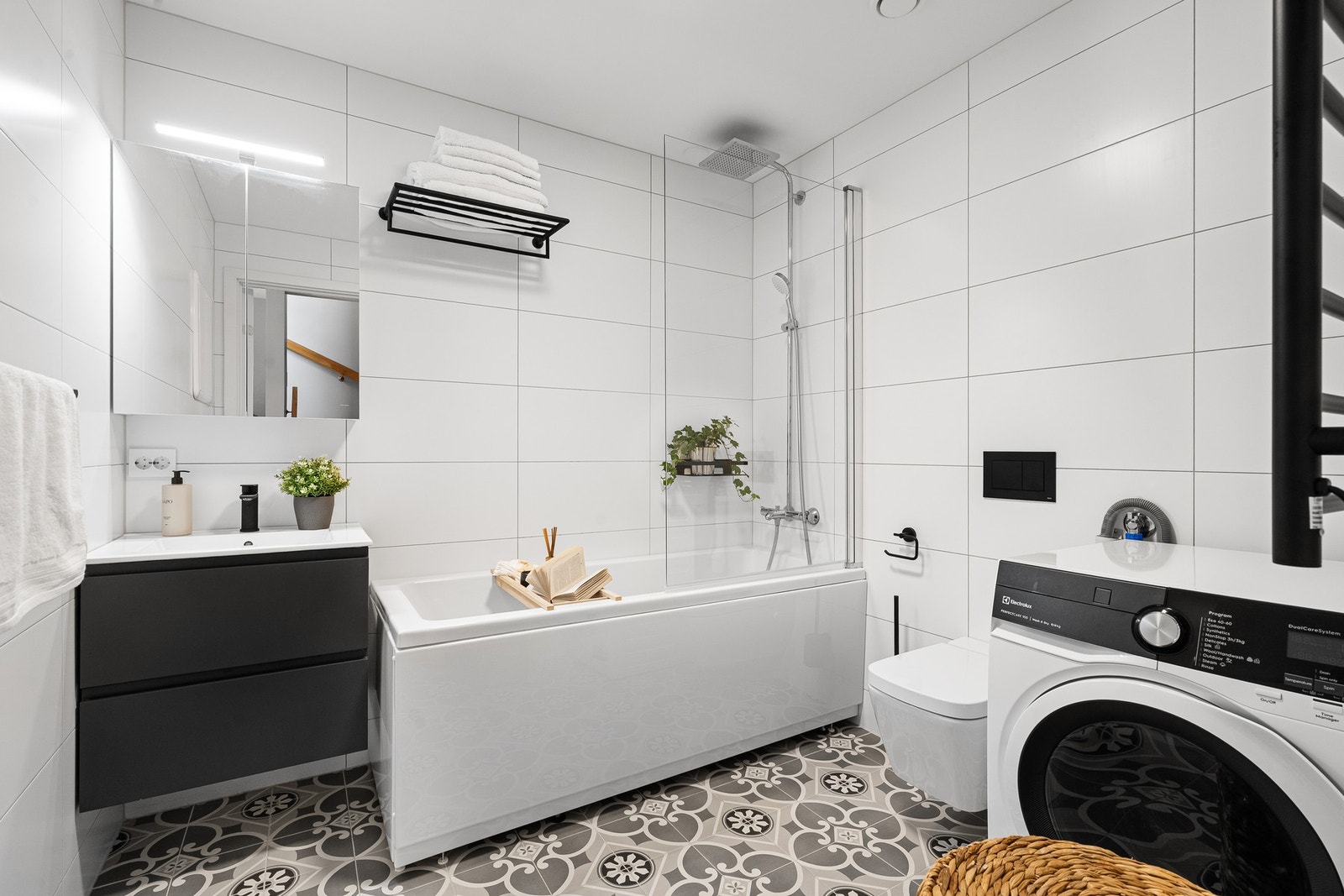 Flislagt baderom med varmekabler. Innredet med opplegg for vaskemaskin/tørketrommel, badekar/dusj, servantmøbel og toalett med spylefunksjon. Galleribilde