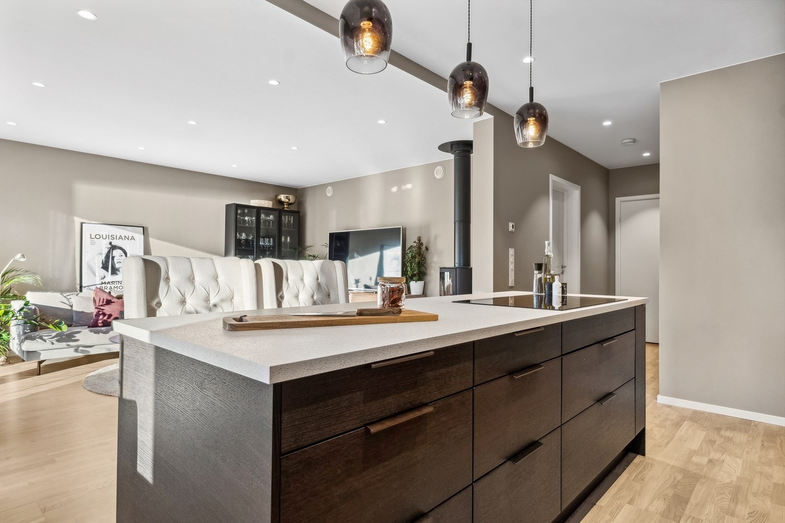 Kjøkkenet har egen kjøkkenøy og mye skapplass. Indusksjonstoppen er montert på kjøkkenøyen. Den åpne løsningen mellom stue og kjøkken gir deg muligheten til å holde samtalene i gang under matlagingen. Galleribilde