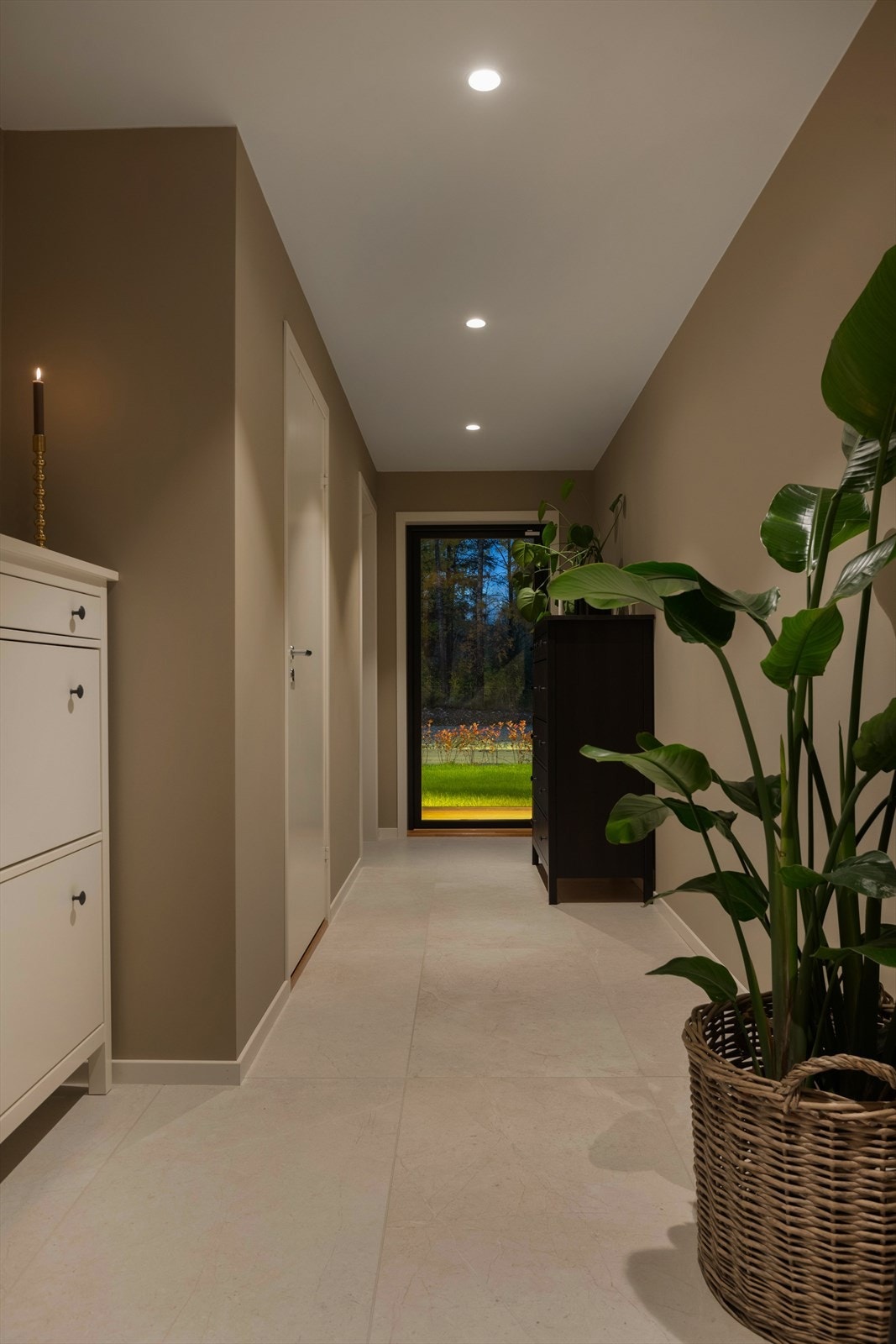 Gangen har rikelig med lys og egen utgang til boligens markterrasse. Galleribilde