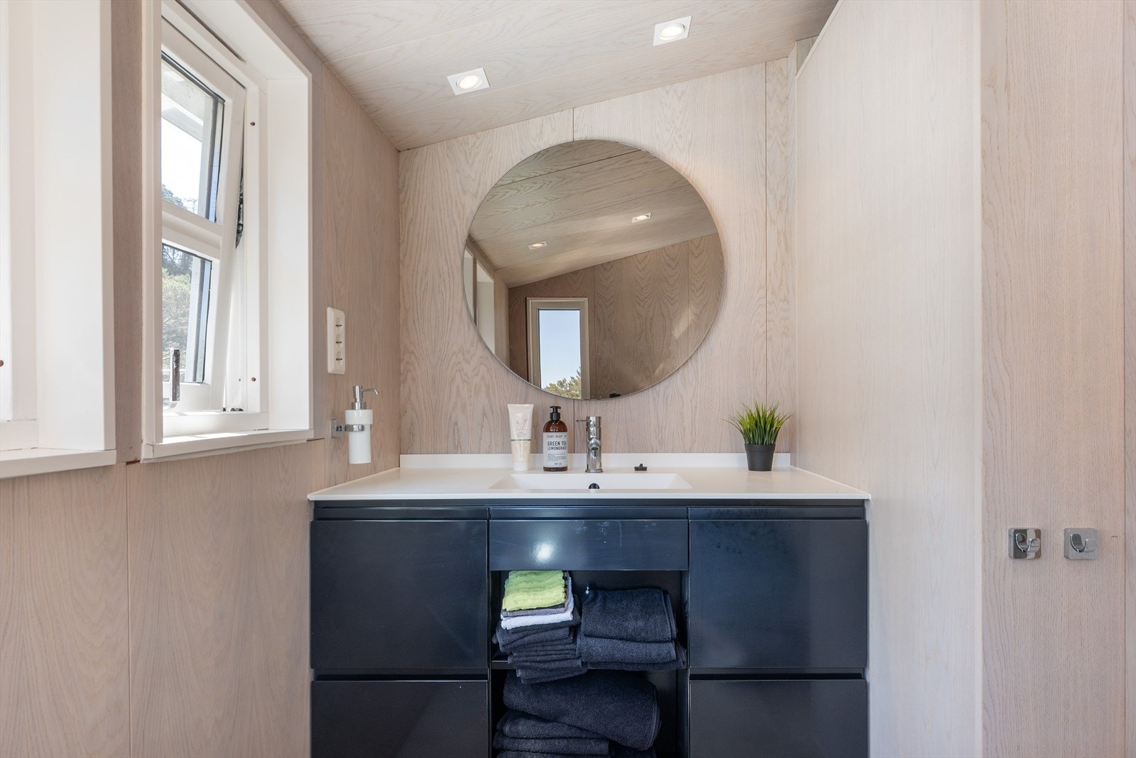 Badet er innredet med helstøpt servant med skuffer under, og speil over vask. Galleribilde