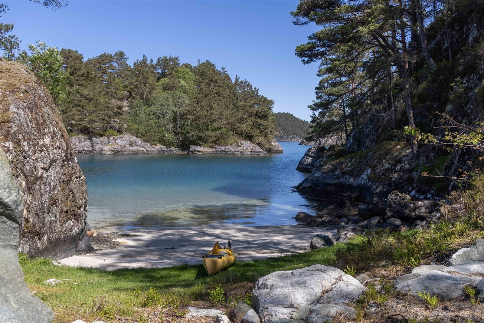 Øyen er omkranset av klart vann og flotte sandstrender, der du kan finne kamskjell helt opp i vannkanten - et lite paradis for både naturelskere og matentusiaster. Galleribilde