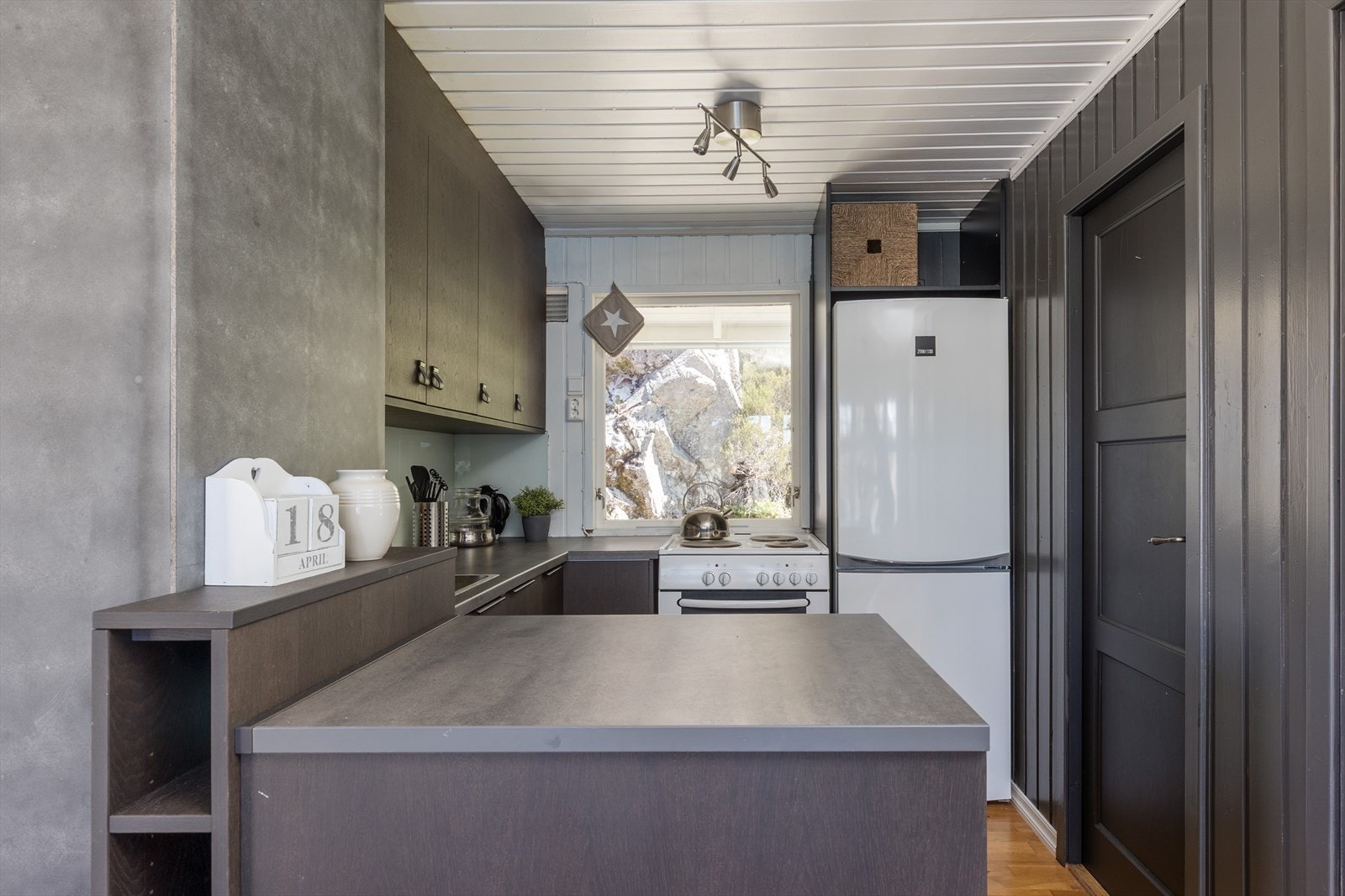 Kjøkkenet har rikelig med skap- og benkeplass. Innredningen er utført med slette fronter i tre, benkeplate av kompaktlaminat, og underlimt vask. Galleribilde