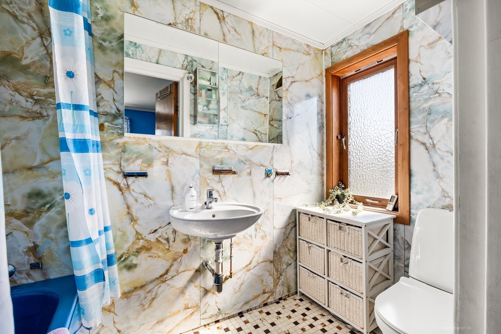 Bad med fliser på gulv. Innredning bestående av badekar, toalett og servant Galleribilde