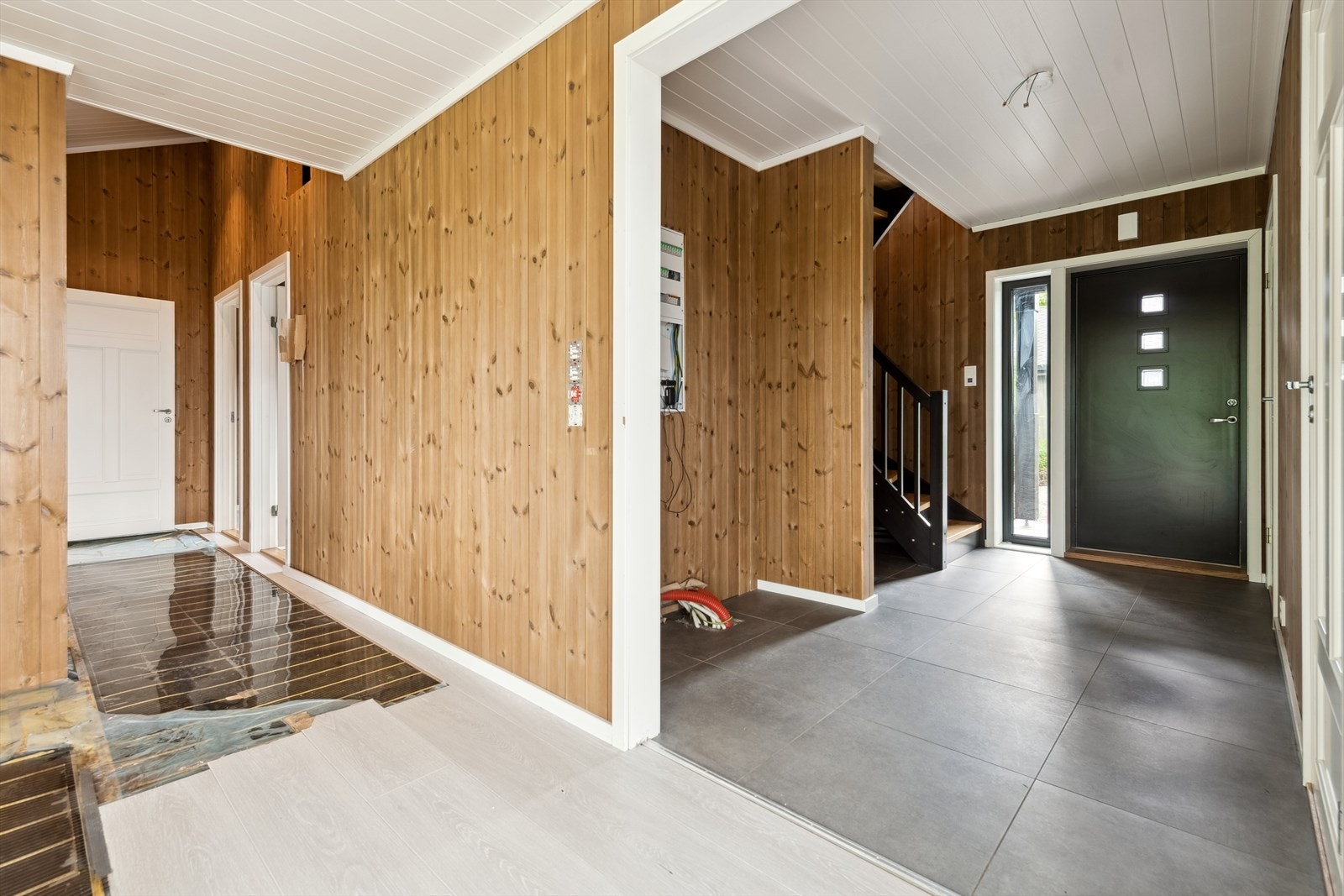 Det er fliser i gang og laminatgulv i stue/kjøkken. En del gulv i kjøkken/gang er revet opp. Galleribilde