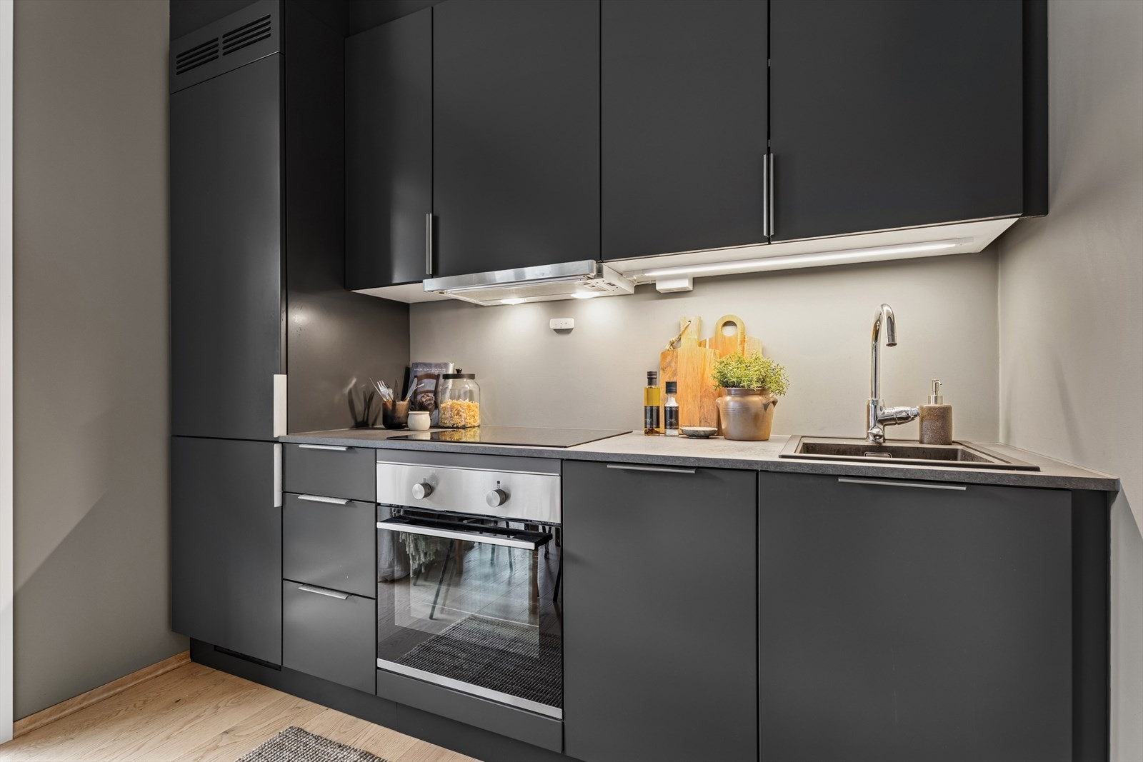 Kjøkkenet er innredet med glatte fronter og laminert benkeplate med kjøkkenkum. Galleribilde