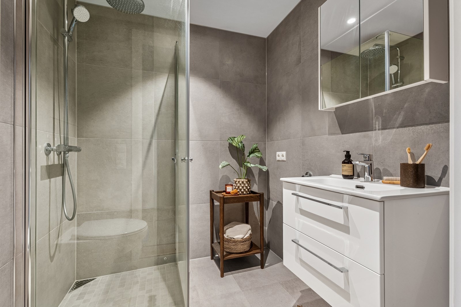 Delikat bad med flislagte overflater og behagelig gulvvarme. Opplegg for vaskemaskin og tørketrommel. Galleribilde